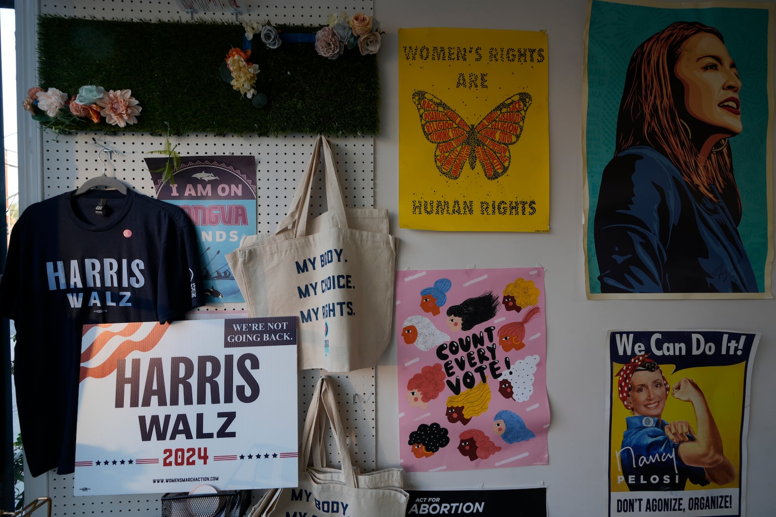 Political posters decorate the walls of the Women's March Foundation during a phone bank in support of Democratic presidential nominee Vice President Kamala Harris on Tuesday, Oct. 15, 2024, in Los Angeles. (AP Photo/Damian Dovarganes)