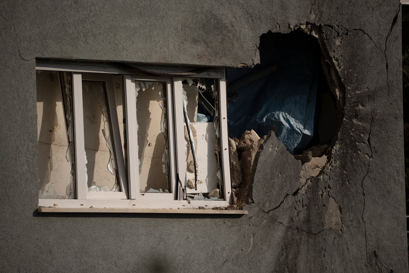 A hole next to a window shows the impact of a rocket fired from Lebanon, on a house of the Kibbutz Manara, located in the upper Galilee, northern Israel, Thursday, Nov. 28, 2024. (AP Photo/Leo Correa)