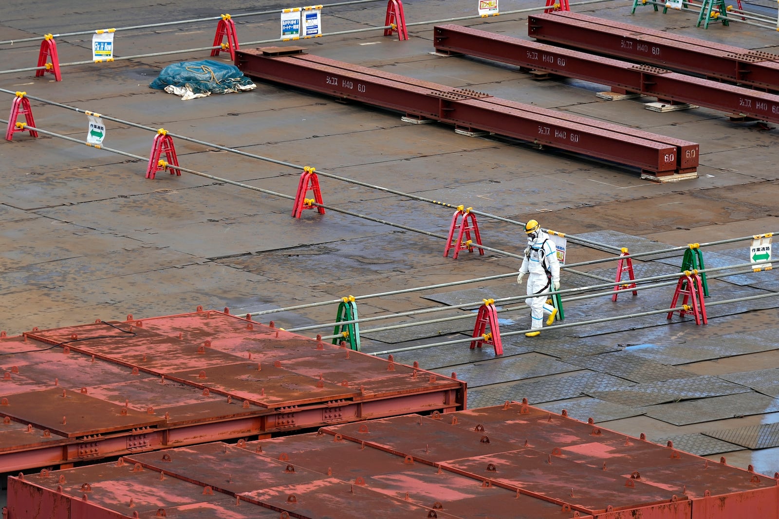 A worker in hazmat suit walks at the Fukushima Daiichi nuclear power plant, operated by Tokyo Electric Power Company Holdings (TEPCO), in Okuma town, northeastern Japan on Monday Feb. 20, 2025. (AP Photo/Eugene Hoshiko)