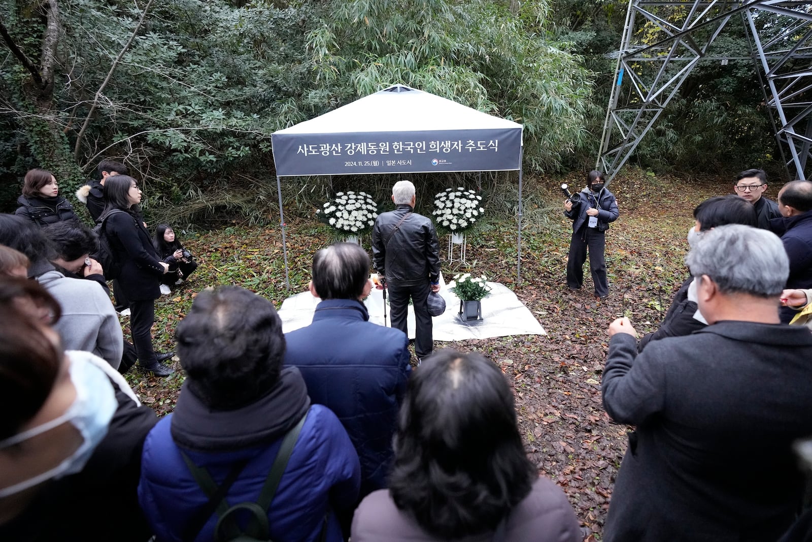 Relatives of Korean victims and South Korean officials offer a prayer during a memorial service at the site of former Fourth Souai Dormitory for the mine workers from the Korean Peninsula, in Sado, Niigata prefecture, Japan, Monday, Nov. 25, 2024, a day after boycotting a memorial organized by Japanese officials. (AP Photo/Eugene Hoshiko)