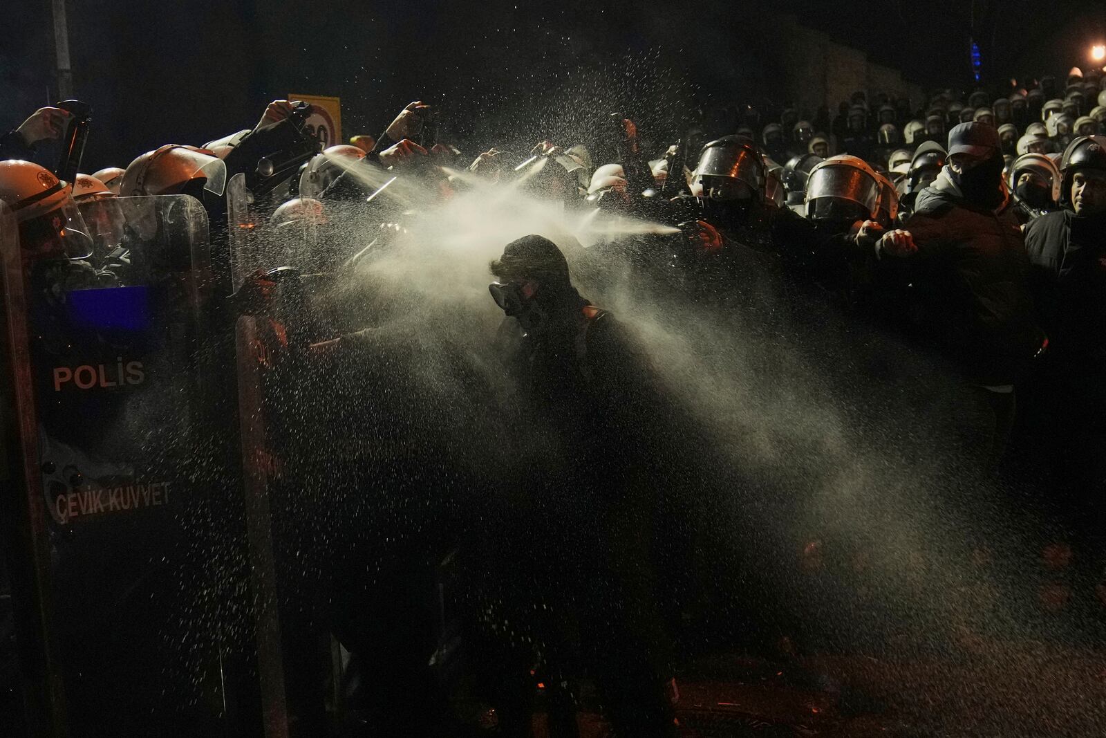 Riot police use pepper spray to clear a protester during a protest against the arrest of Istanbul's Mayor Ekrem Imamoglu, in Istanbul, Turkey, Saturday, March 22, 2025. (AP Photo/Khalil Hamra)