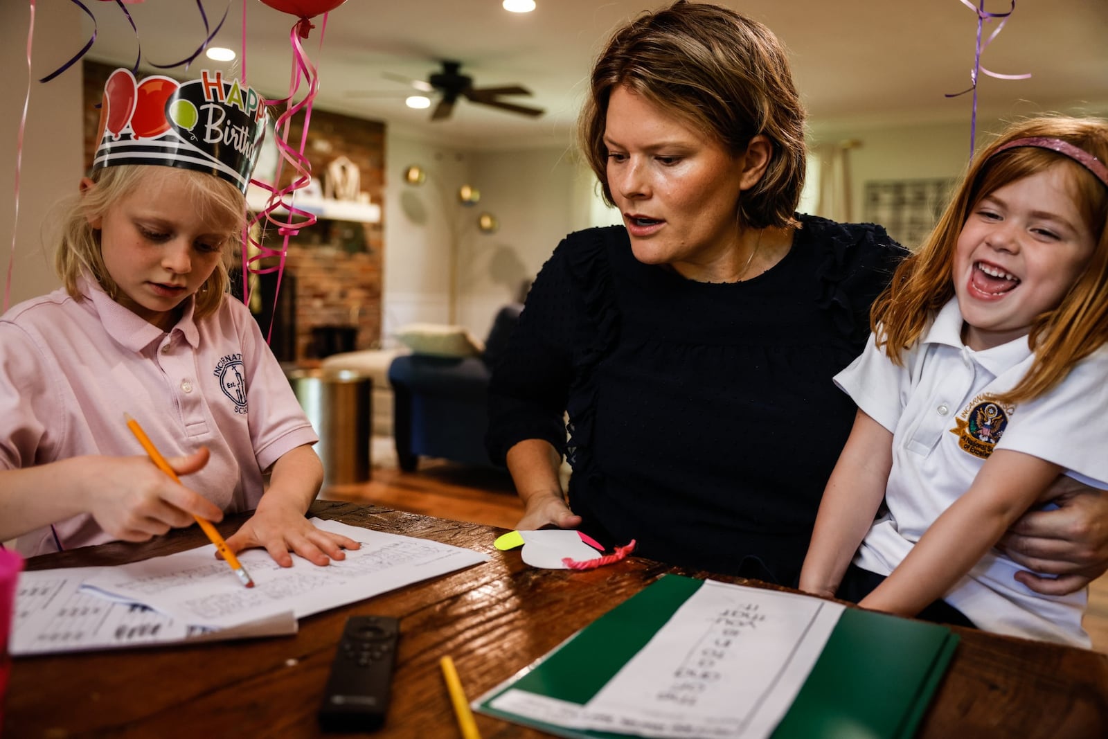 Kate Vriner and her daughters Rita, left, and Evelyn go over homework after school. The Centerville family has been juggling child care and work during the pandemic. JIM NOELKER/STAFF