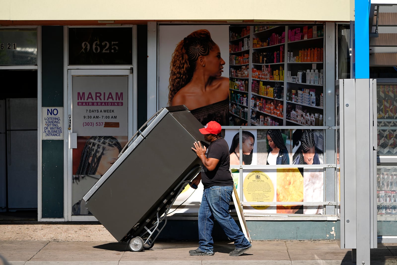 A worker wheels a refrigerator into a used appliance store along East Colfax at Dallas Street, Wednesday, Oct. 9, 2024, in the east Denver suburb of Aurora, Colo. (AP Photo/David Zalubowski)