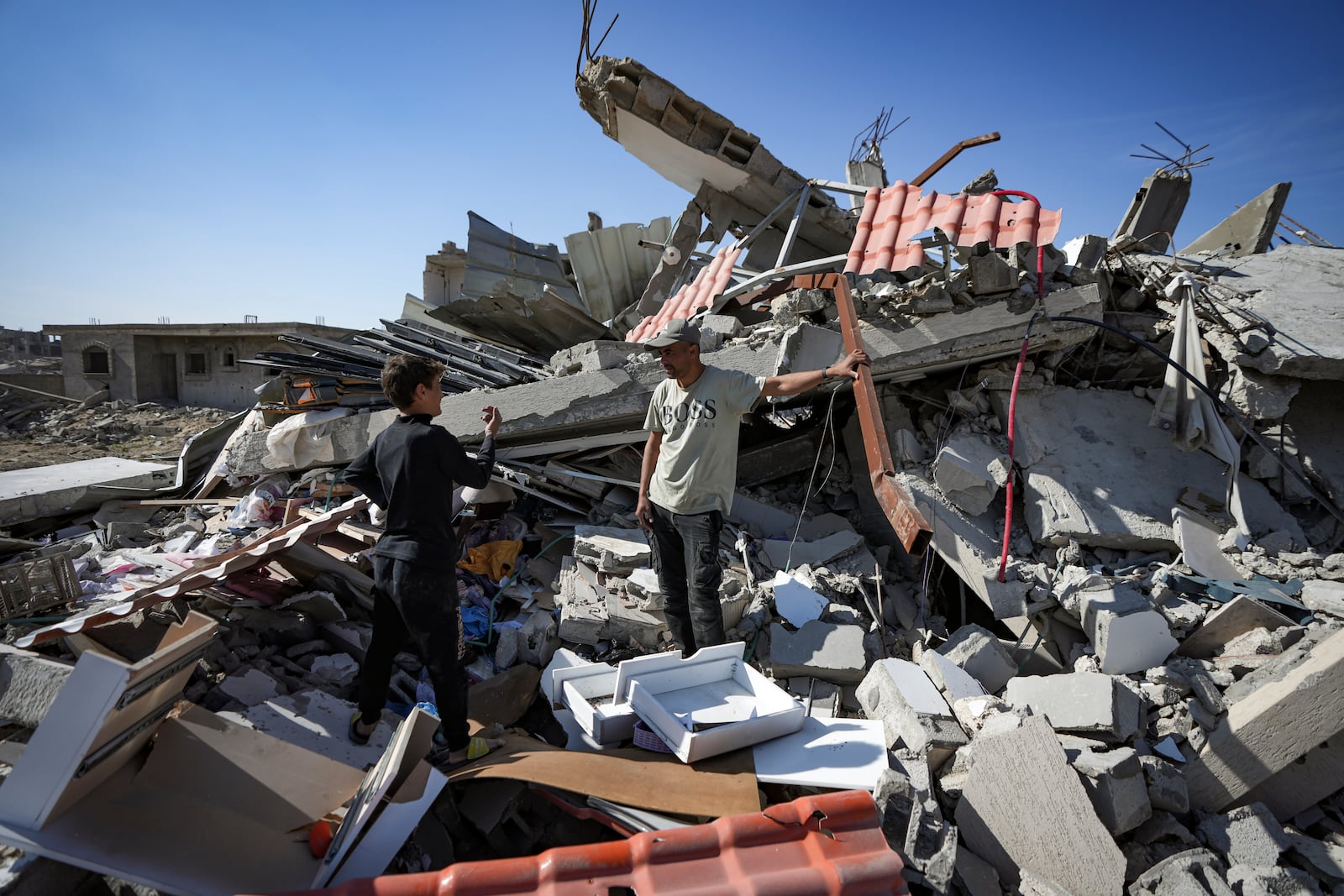 Murad Muqdad, center, stands amid the rubble of his destroyed home, in Rafah, southern Gaza Strip, Tuesday, Jan. 21, 2025, days after the ceasefire deal between Israel and Hamas came into effect. (AP Photo/Abdel Kareem Hana)