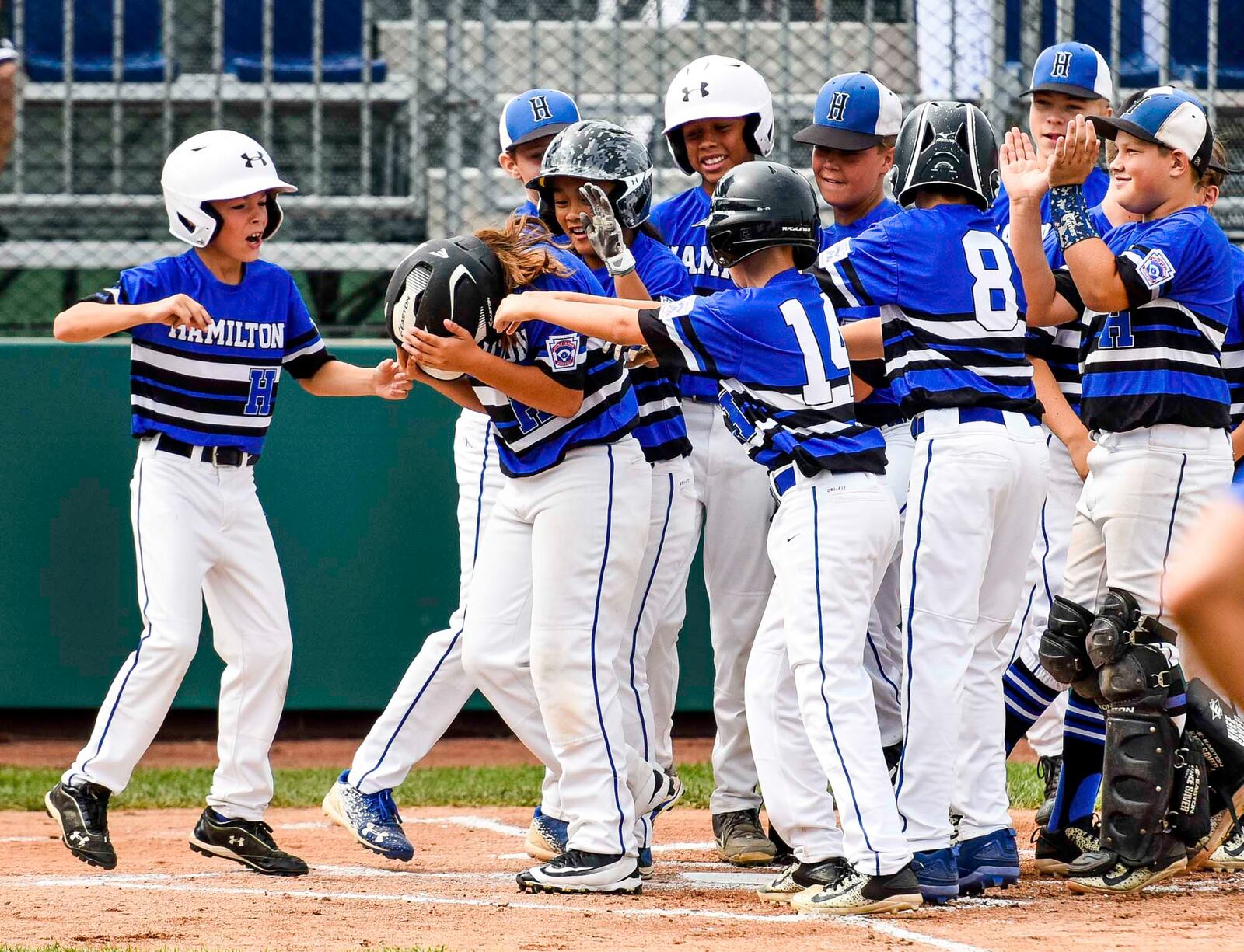 Teammates wait at home plate after West Side Little League's Jaycee Taylor hits a 2-run home run during their 10-2 win over Grosse Pointe Woods/Shores Little League, from Michigan, in their Little League Great Lakes Regional tournament Monday, Aug. 7, 2017, at Grand Park Sports Campus in Westfield, Indiana. NICK GRAHAM/STAFF