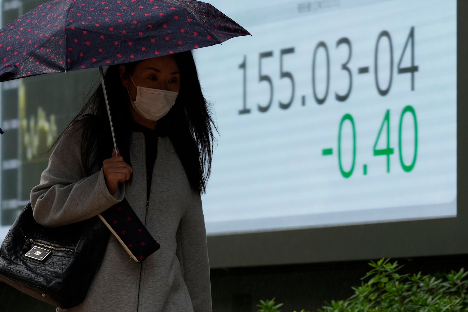 A woman walks by a monitor showing Japan's foreign exchange rate against the U.S. dollar at a securities firm in Tokyo, Thursday, Nov. 21, 2024. (AP Photo/Hiro Komae)