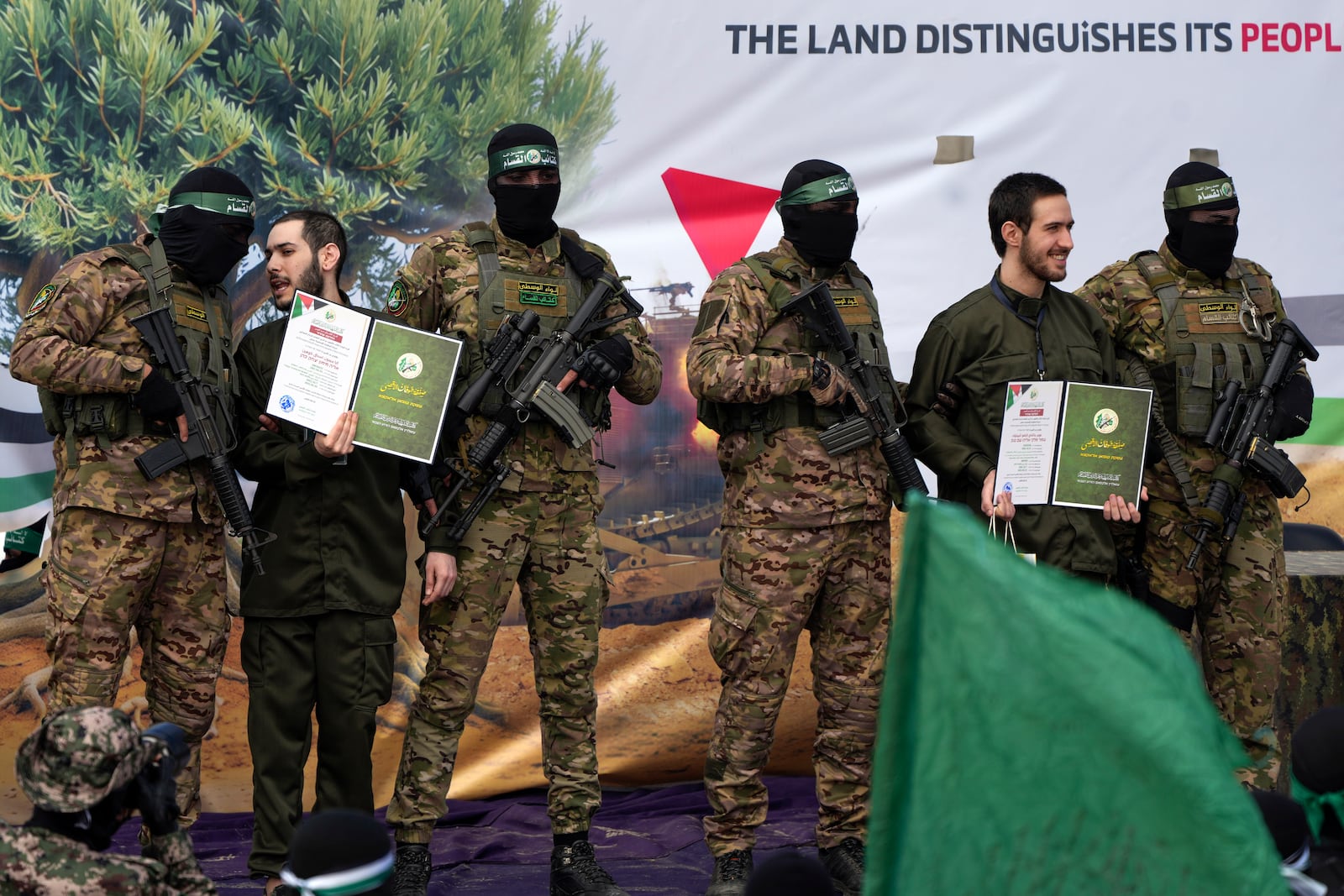 Israeli hostages Eliya Cohen, left, and Omer Shem Tov are escorted by Hamas fighters before being handed over to the Red Cross in Nuseirat, central Gaza Strip, Saturday, Feb. 22, 2025. (AP Photo/Abdel Kareem Hana)