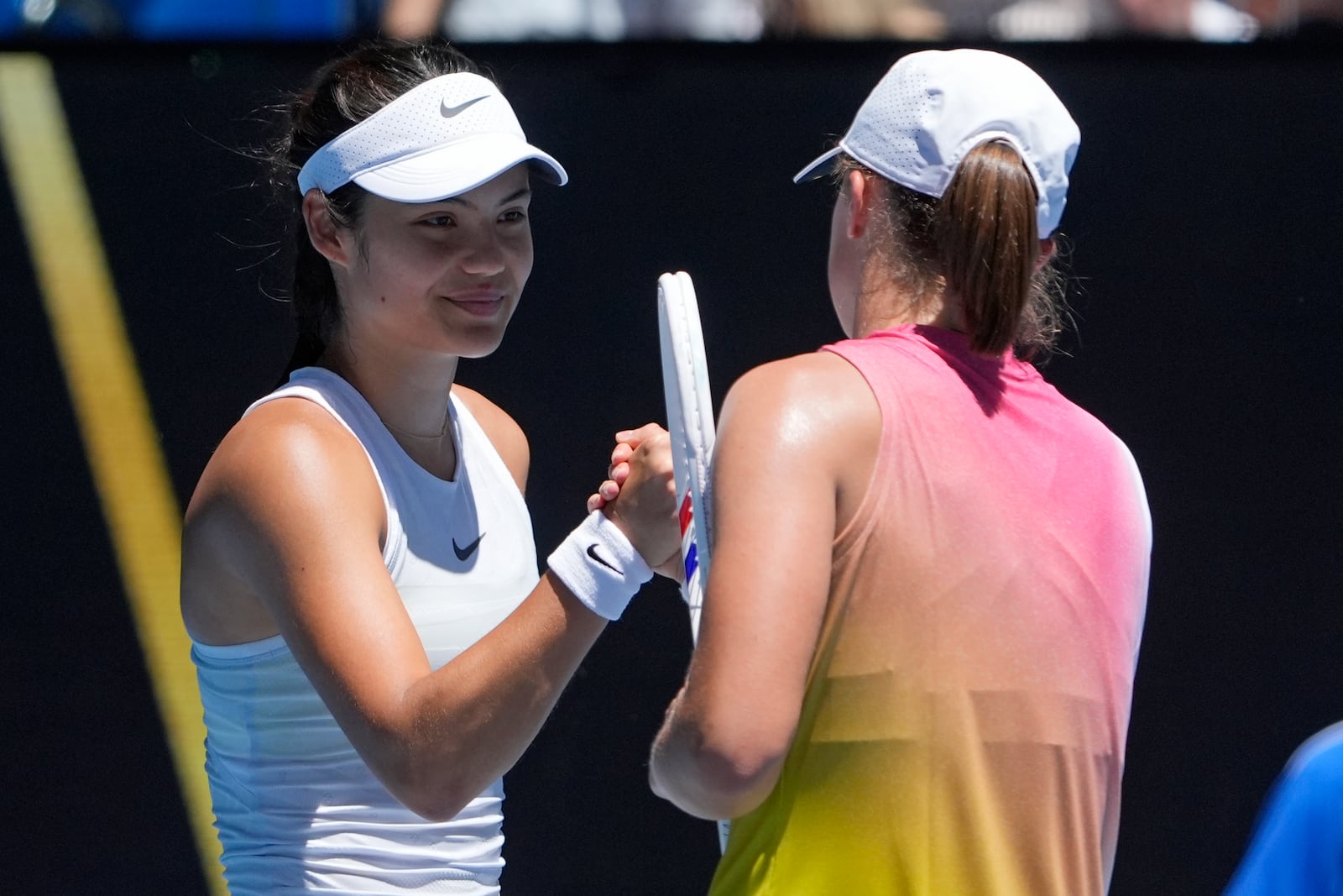 Emma Raducanu of Britain congratulates Iga Swiatek, right, of Poland following their third round match at the Australian Open tennis championship in Melbourne, Australia, Saturday, Jan. 18, 2025. (AP Photo/Asanka Brendon Ratnayake)