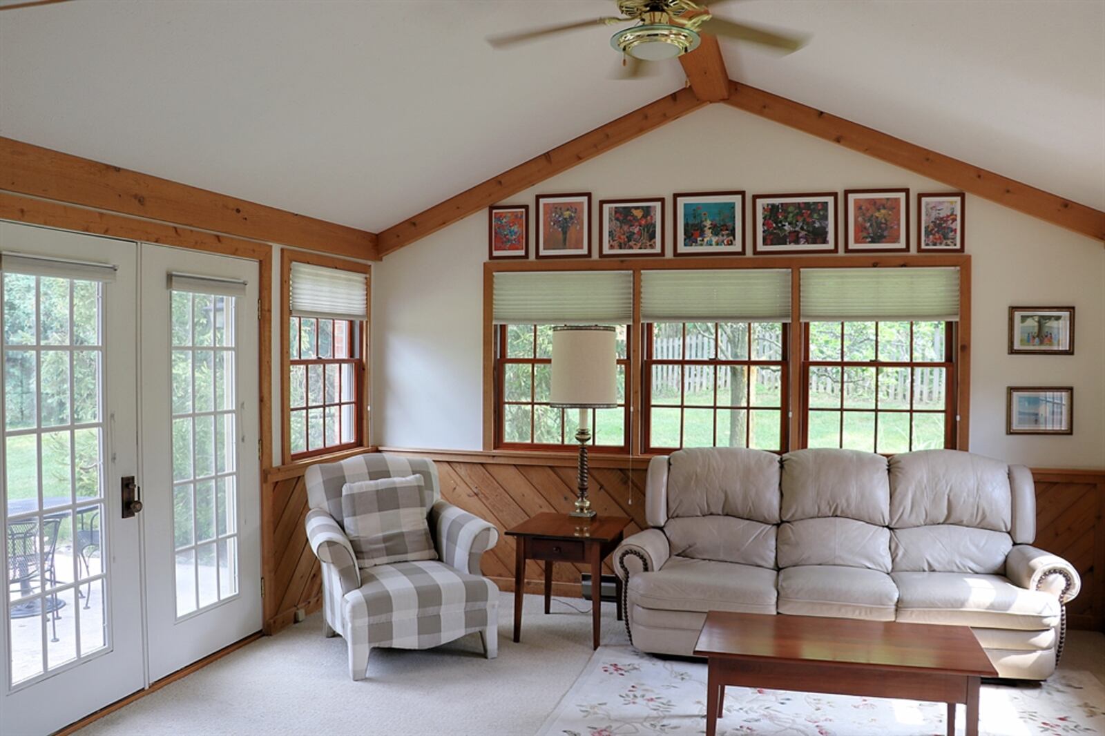 The four-season room has a wood-beam accented cathedral ceiling.