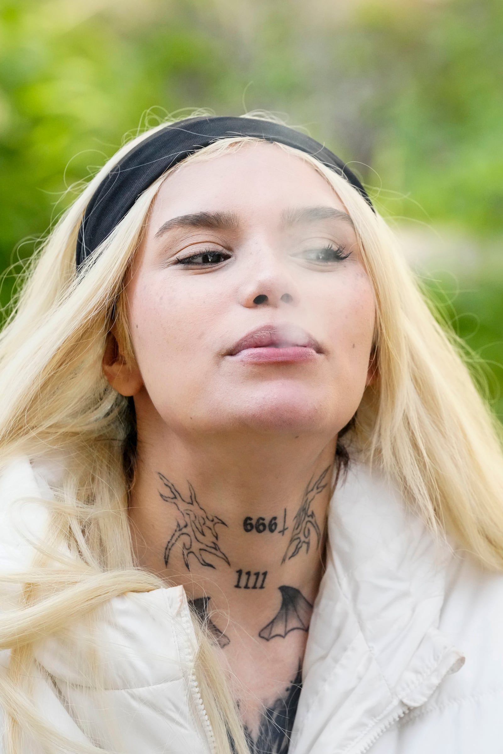 Siuling Andrade, a member of The Temple of Satan: Satanists and Luciferians of Chile, smokes a cigarette after taking part in ceremony at the General Cemetery in Santiago, Saturday, Sept. 14, 2024. (AP Photo/Esteban Felix)