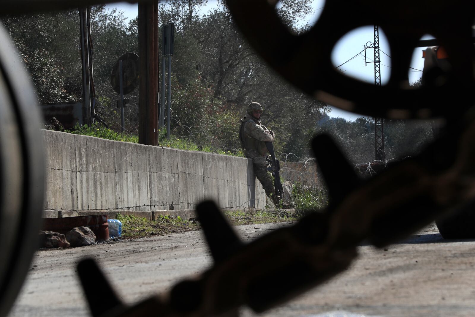 A Lebanese soldier stand guards on a road blocked by Israeli soldiers, where citizens gather to return to their villages near the southern Lebanese village of Kfar Kila, Lebanon, Sunday, Feb. 2, 2025.(AP Photo/Mohammed Zaatari)