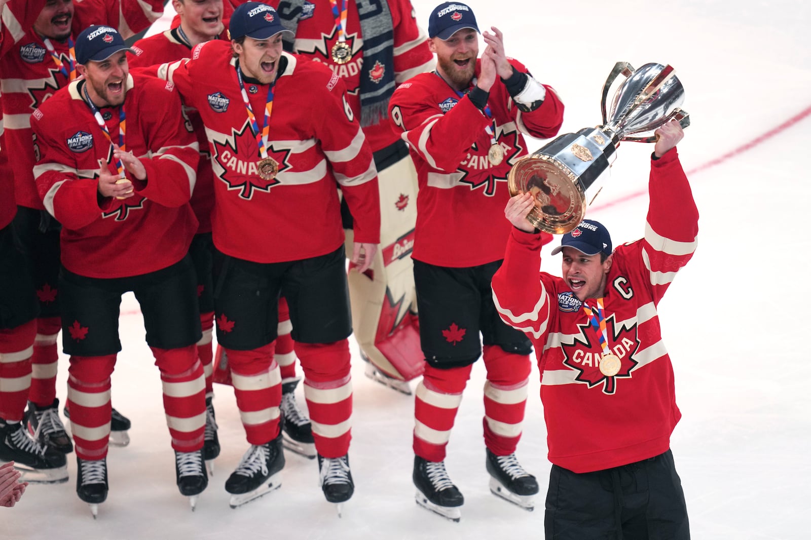 Canada captain Sidney Crosby, right, hoists the trophy after defeating the United States following an overtime period of the 4 Nations Face-Off championship hockey game, Thursday, Feb. 20, 2025, in Boston. (AP Photo/Charles Krupa)