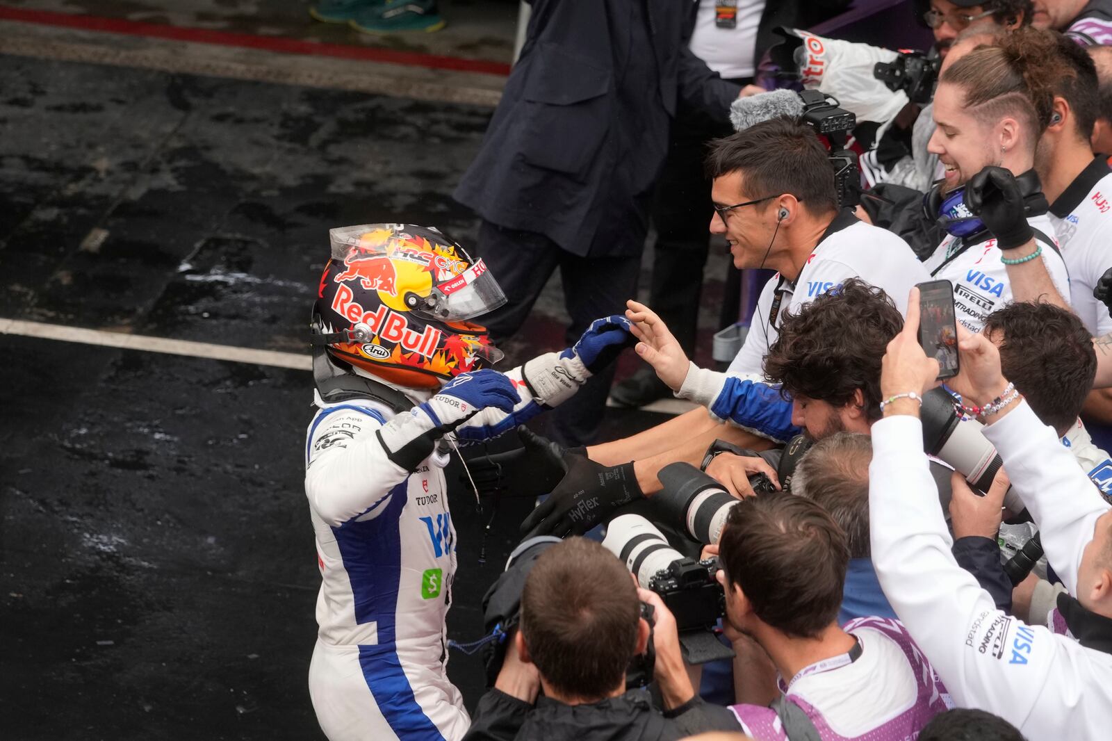 RB driver Yuki Tsunoda of Japan, left, celebrates his third place after the qualifying session ahead of the Brazilian Formula One Grand Prix at the Interlagos race track, in Sao Paulo, Brazil, Sunday, Nov. 3, 2024. (AP Photo/Andre Penner)