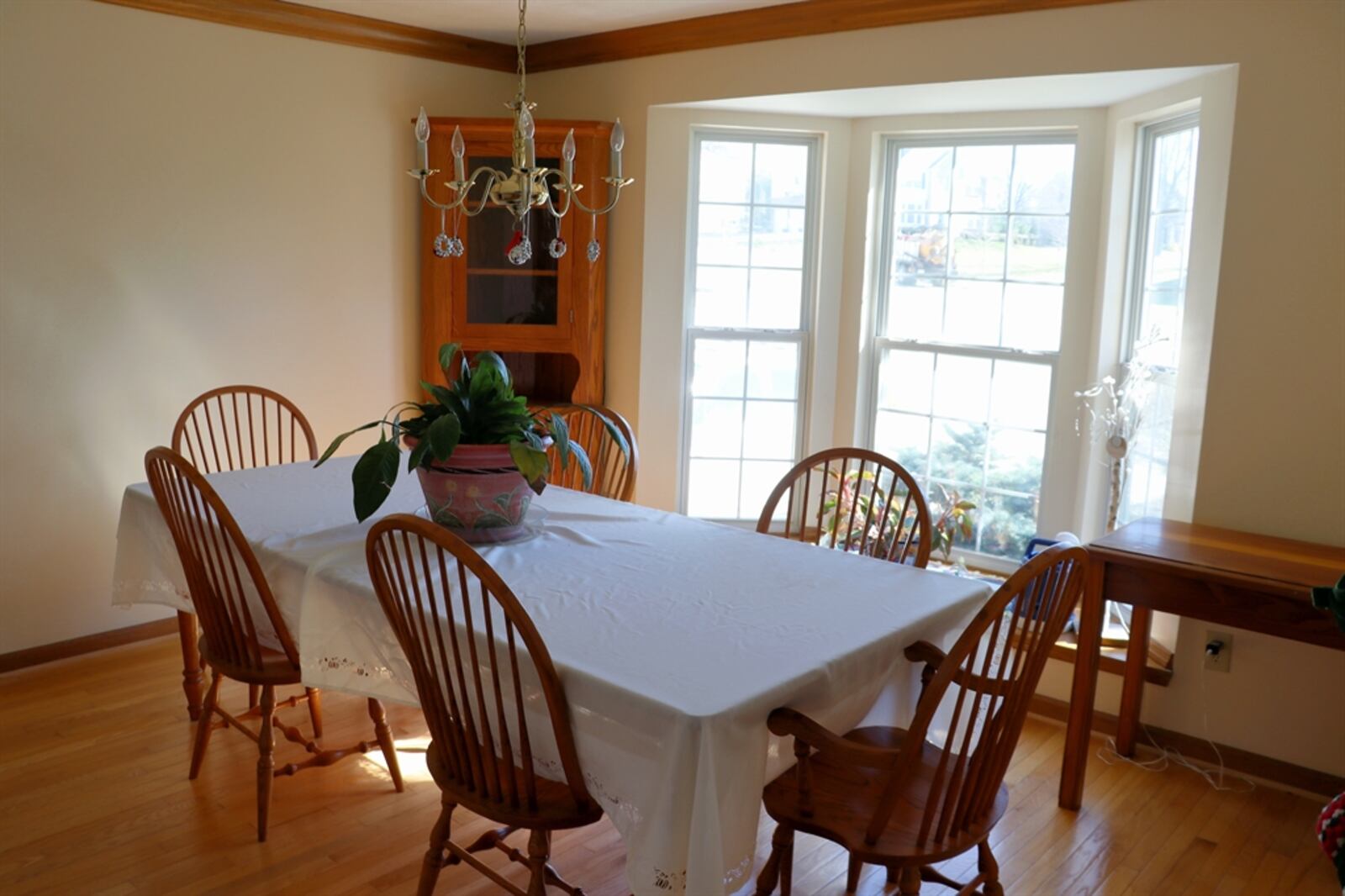 The breakfast room has been expanded with a bay bump-out design with tall windows and double-glass doors that open out to the balcony wooden deck.