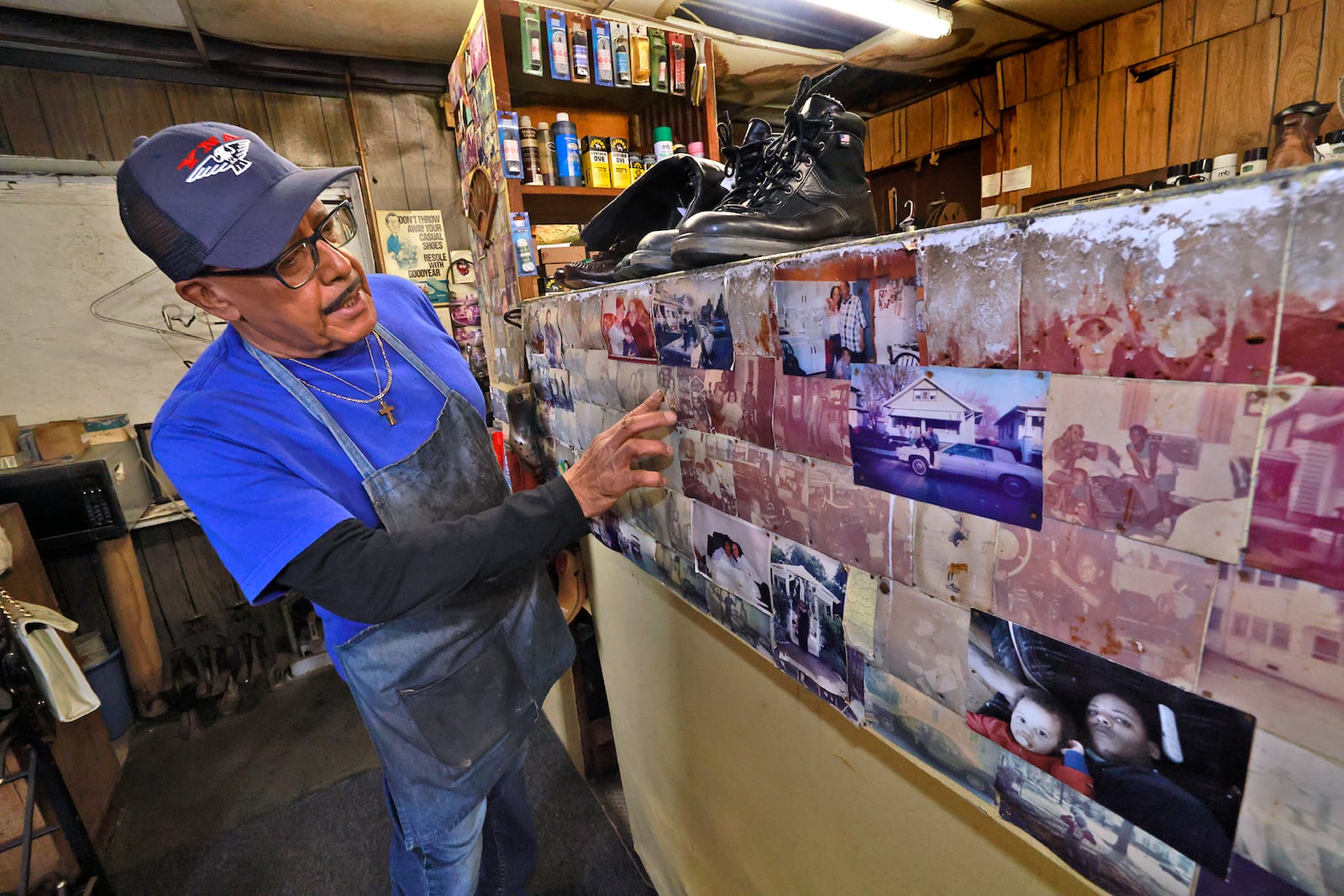 Clifford proudly talks about the faded photos of his children, who both worked in the shop when they were young. BILL LACKEY/STAFF