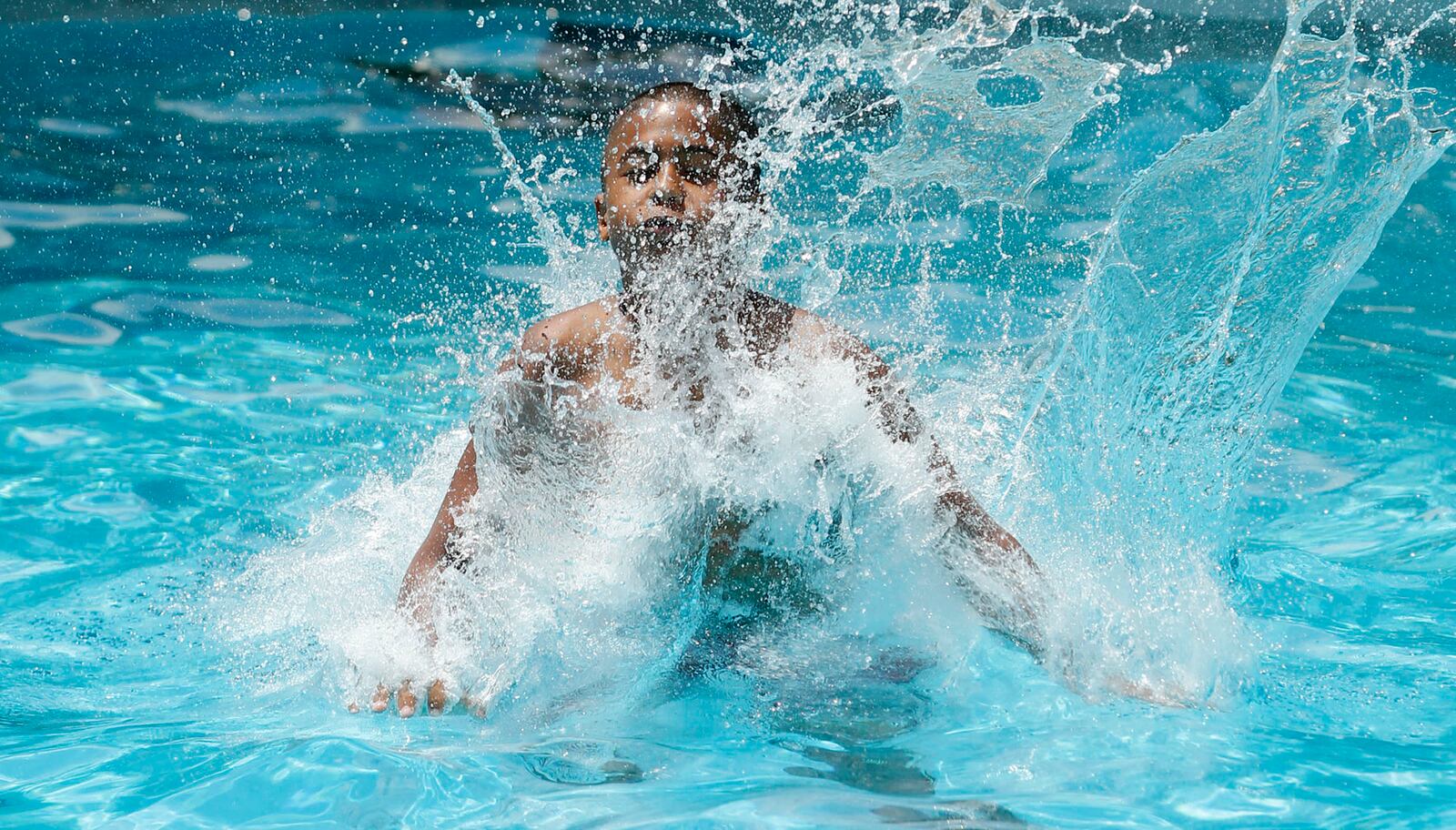 Michael Barnes from the diving board at the Kroger Aquatics Center at The Heights on a warm Tuesday afternoon. The parking lot of the water park was almost full by noon. TY GREENLEES / STAFF