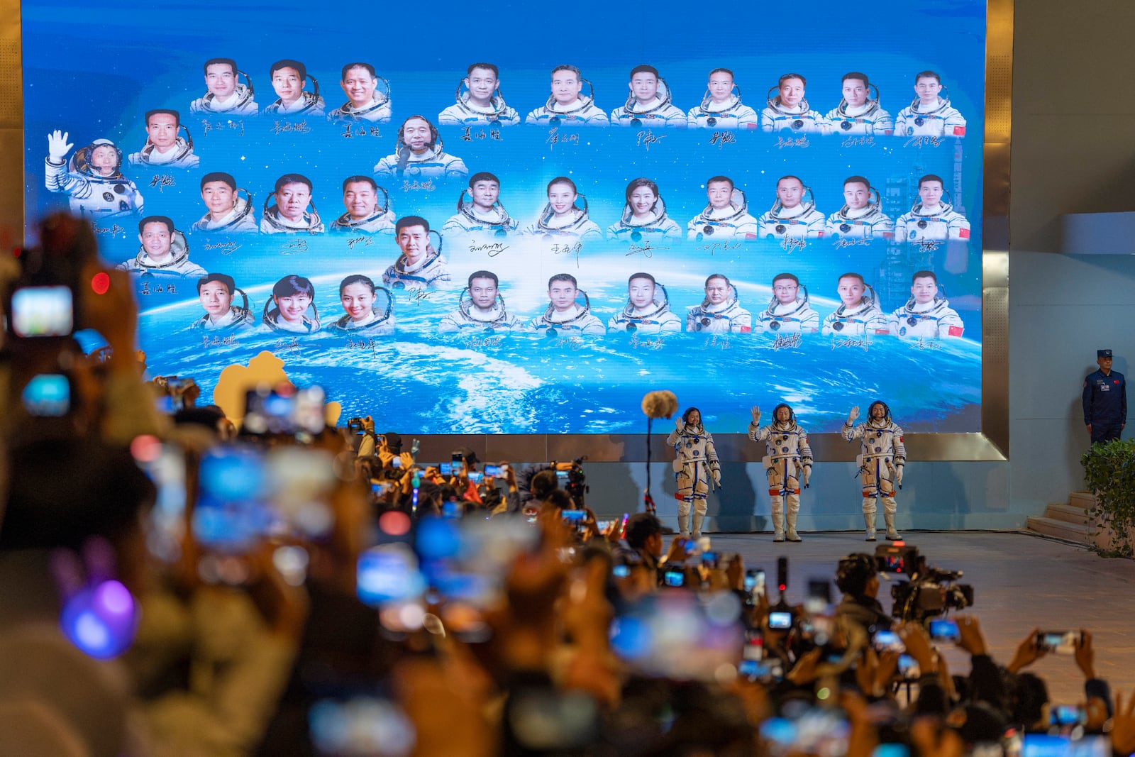 Chinese astronauts Wang Haoze, from left, Cai Xuzhe and Song Lingdong wave as they prepare to depart on the Shenzhou-19 mission at the Jiuquan Satellite Launch Center in northwestern China, in the early hours of Wednesday, Oct. 30, 2024. (AP Photo/Ng Han Guan)