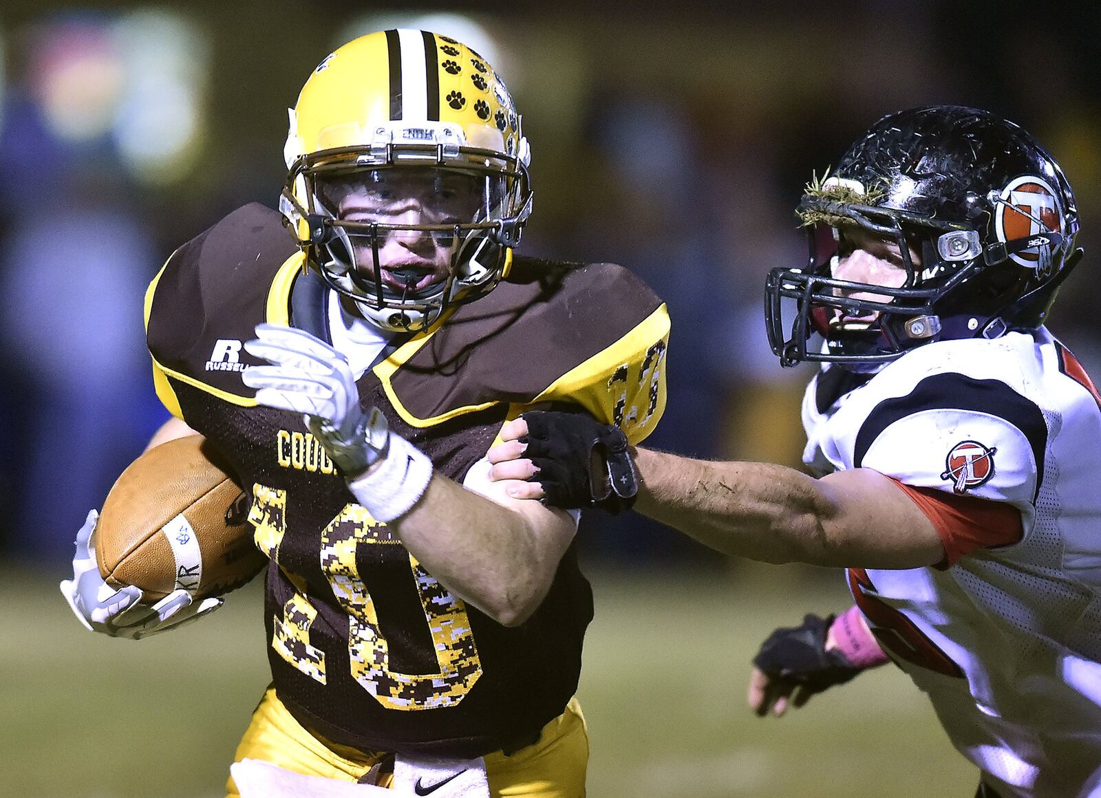 Kenton Ridge’s Mitchell Schneider tries to avoid a tackle by Tecumseh’s Steven Marker as he carries the ball during Friday’s game. Bill Lackey/Staff