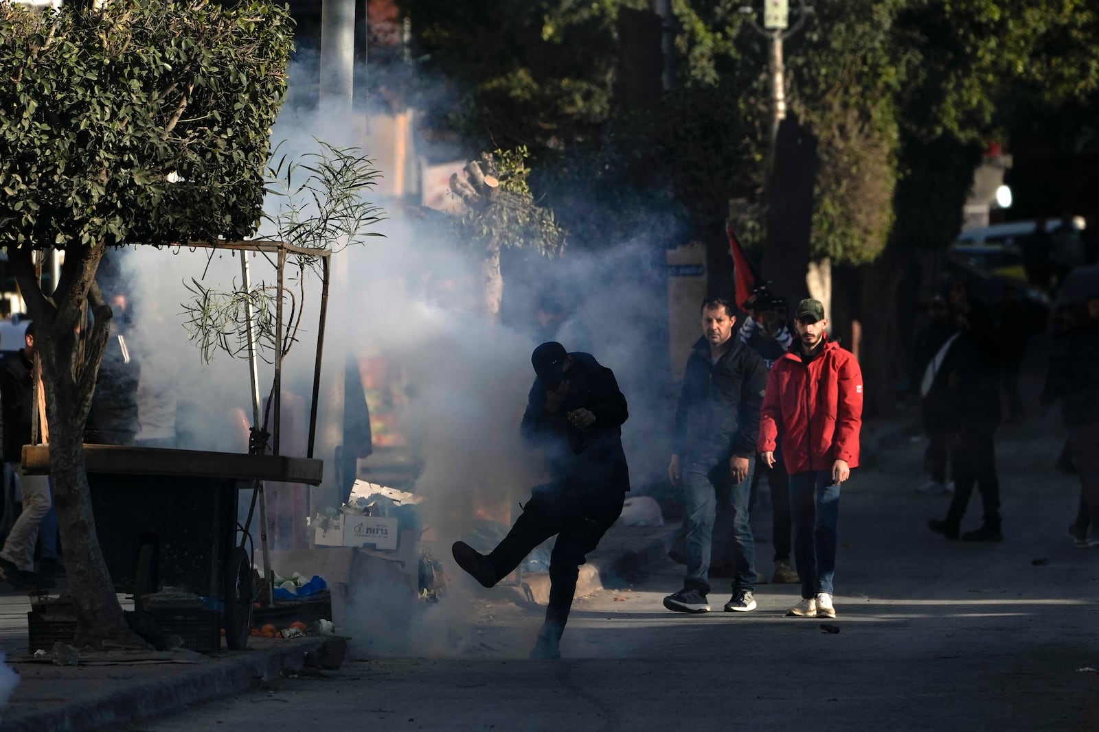 Palestinian youth clash with Palestinian security forces on the third day of a raid, outside the Jenin refugee camp in the Israeli-occupied West Bank, Monday, Dec. 16, 2024.(AP Photo/Majdi Mohammed).