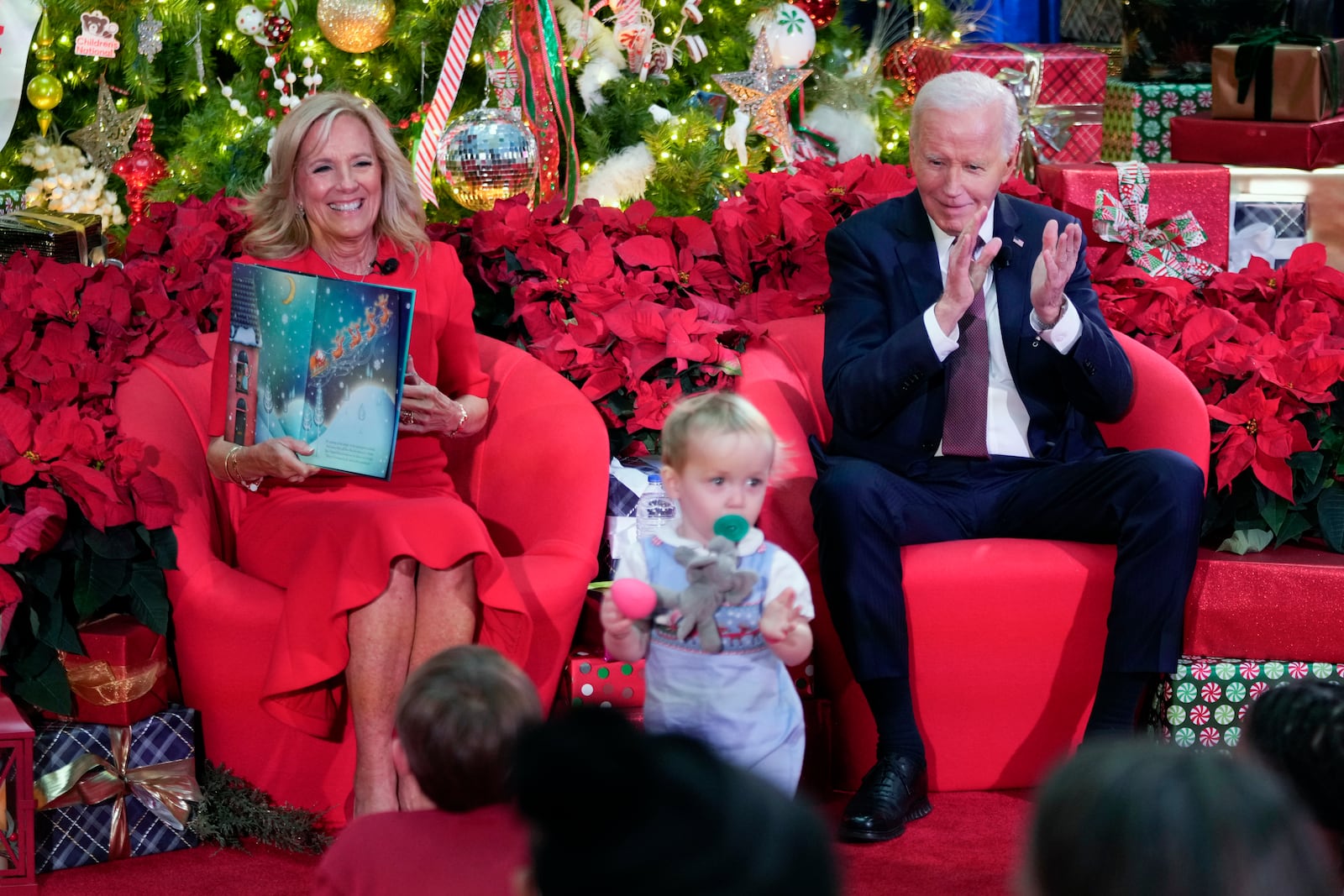 President Joe Biden and first lady Jill Biden, as she reads 'Twas the Night Before Christmas, visit patients and families at the Children's National Hospital in Washington, Friday, Dec. 20, 2024. (AP Photo/Ben Curtis)