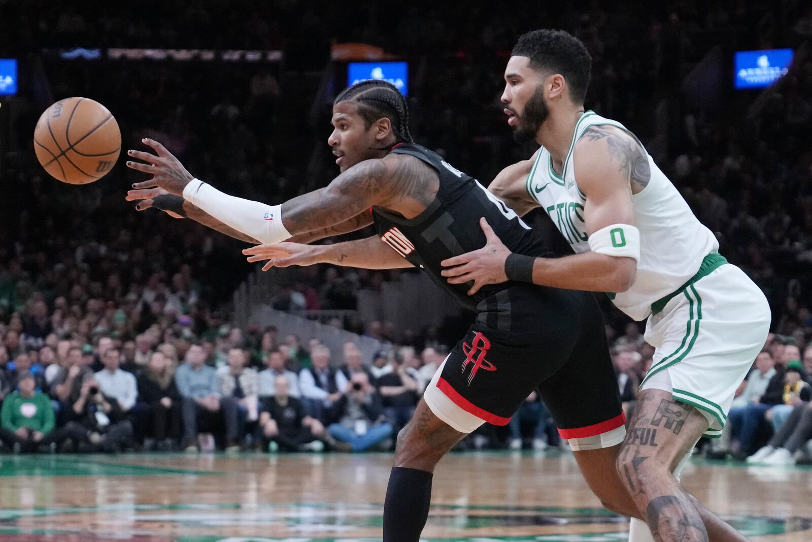 Houston Rockets guard Jalen Green, left, passes the ball while pressured by Boston Celtics forward Jayson Tatum during the first half of an NBA basketball game, Monday, Jan. 27, 2025, in Boston. (AP Photo/Charles Krupa)