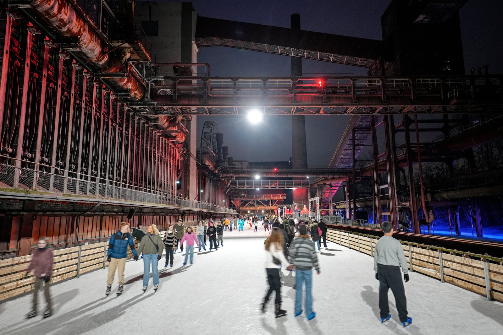 FILE - People skate on an ice rink at what was once the hottest place in the city, the former coking plant Zollverein in Essen, Germany, Tuesday, Dec. 17, 2024. (AP Photo/Martin Meissner, File)