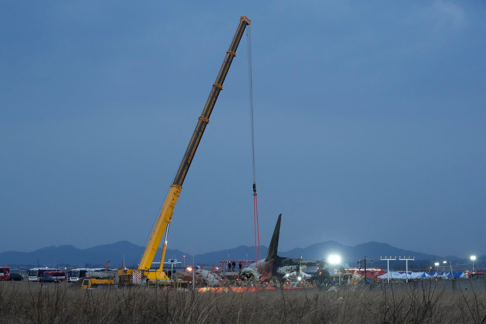 Rescue team members work at the site of a plane fire at Muan International Airport in Muan, South Korea, Sunday, Dec. 29, 2024. (AP Photo/Ahn Young-joon)