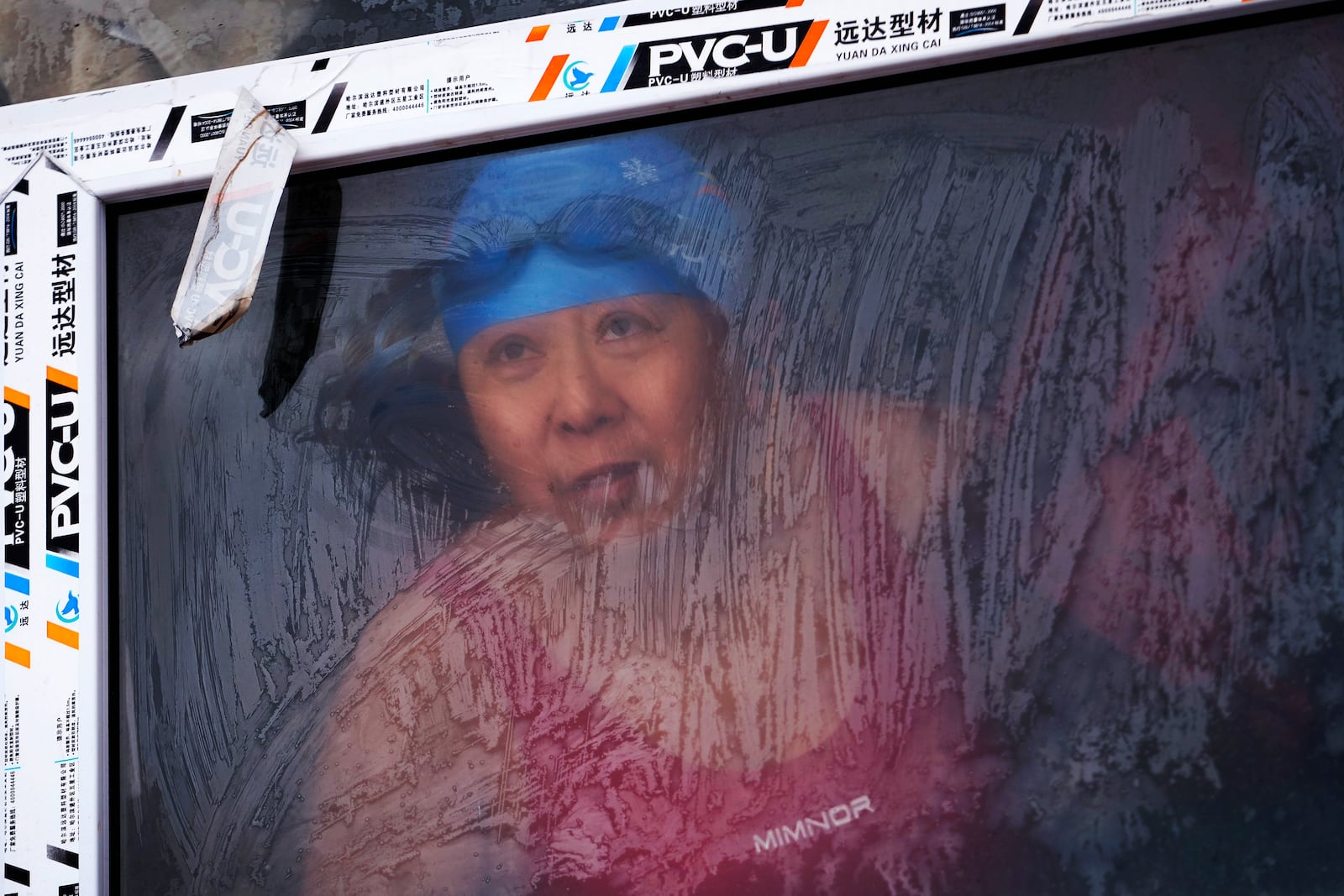 A woman looks out from a changing room as she prepares to swim in the frozen Songhua river in Harbin in northeastern China's Heilongjiang province, Tuesday, Jan. 7, 2025. (AP Photo/Andy Wong)