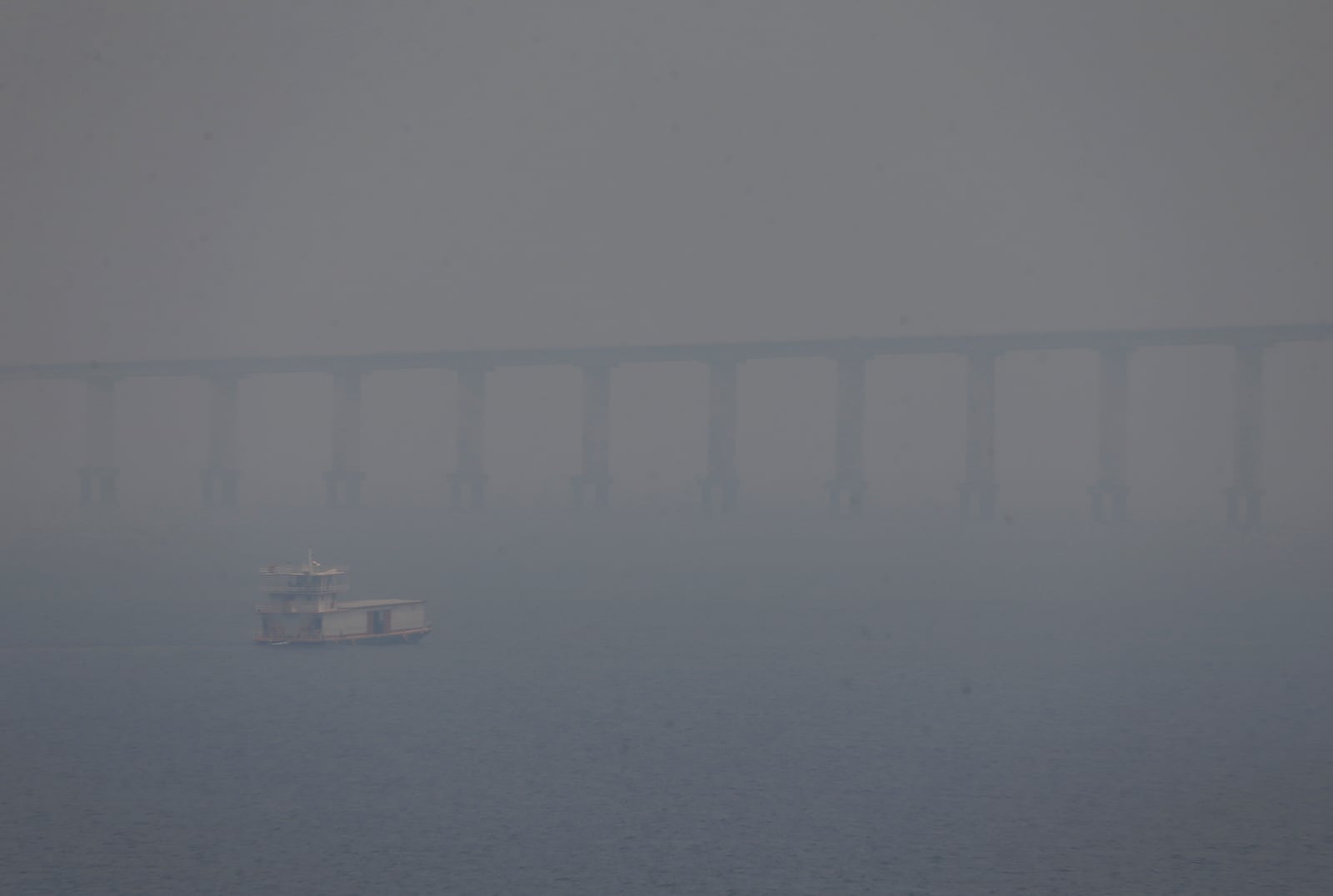 FILE - A boat navigates the Negro River amid smoke from wildfires in Manaus, Amazonas state, Brazil, Aug. 27, 2024. (AP Photo/Edmar Barros, File)