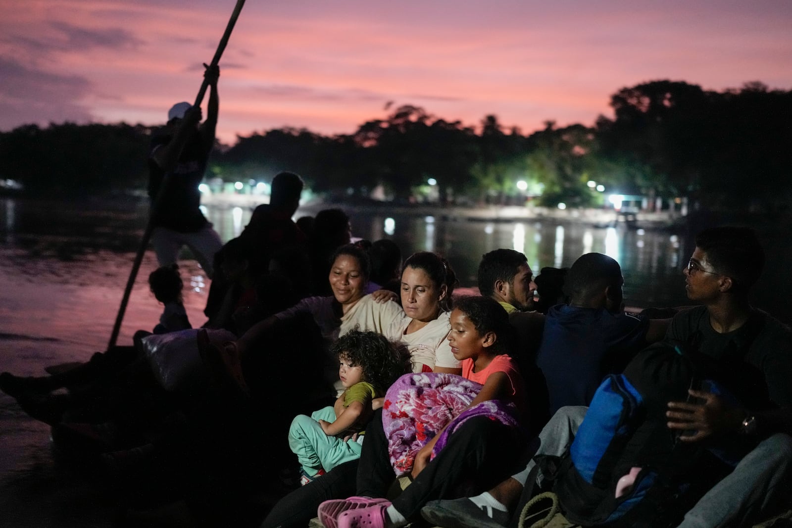 Venezuelan migrant Lisbeth Contreras hugs her children as she crosses the Suchiate River, which marks the border between Guatemala and Mexico, from Tecun Uman, Guatemala, Saturday, Oct. 26, 2024. (AP Photo/Matias Delacroix)