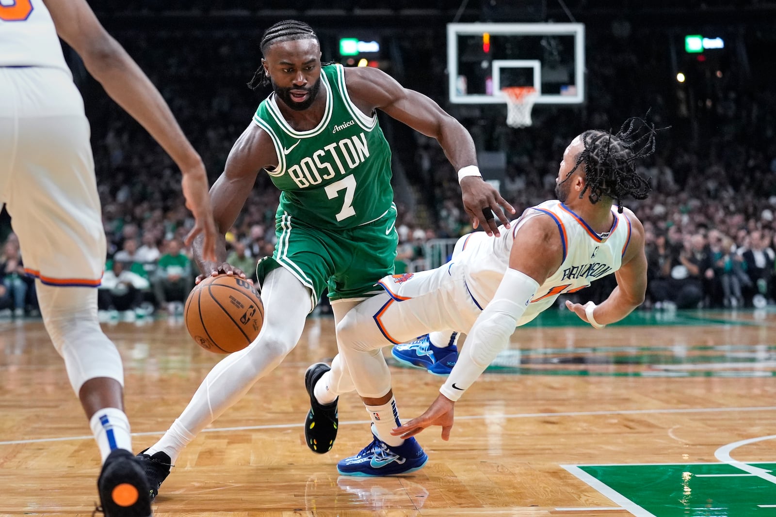 New York Knicks guard Jalen Brunson, right, falls back after fouling Boston Celtics guard Jaylen Brown (7) during the second half of an NBA basketball game, Tuesday, Oct. 22, 2024, in Boston. (AP Photo/Charles Krupa)