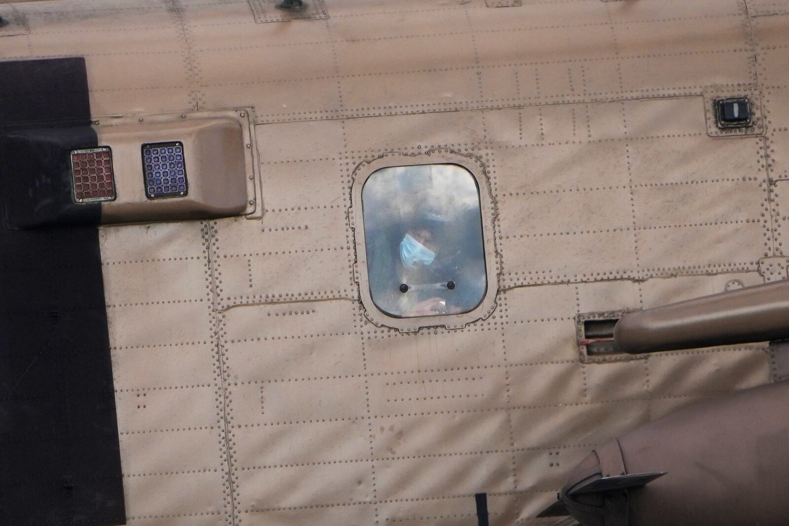 A person peers from a Israeli military helicopter carrying Israel hostages as landing at the Sheba Hospital in Ramat Gan, Israel, on Saturday, Feb. 8, 2025, after they were released from Hamas captivity in Gaza as part of the Israel-Hamas ceasefire deal. (AP Photo/Ariel Schalit)