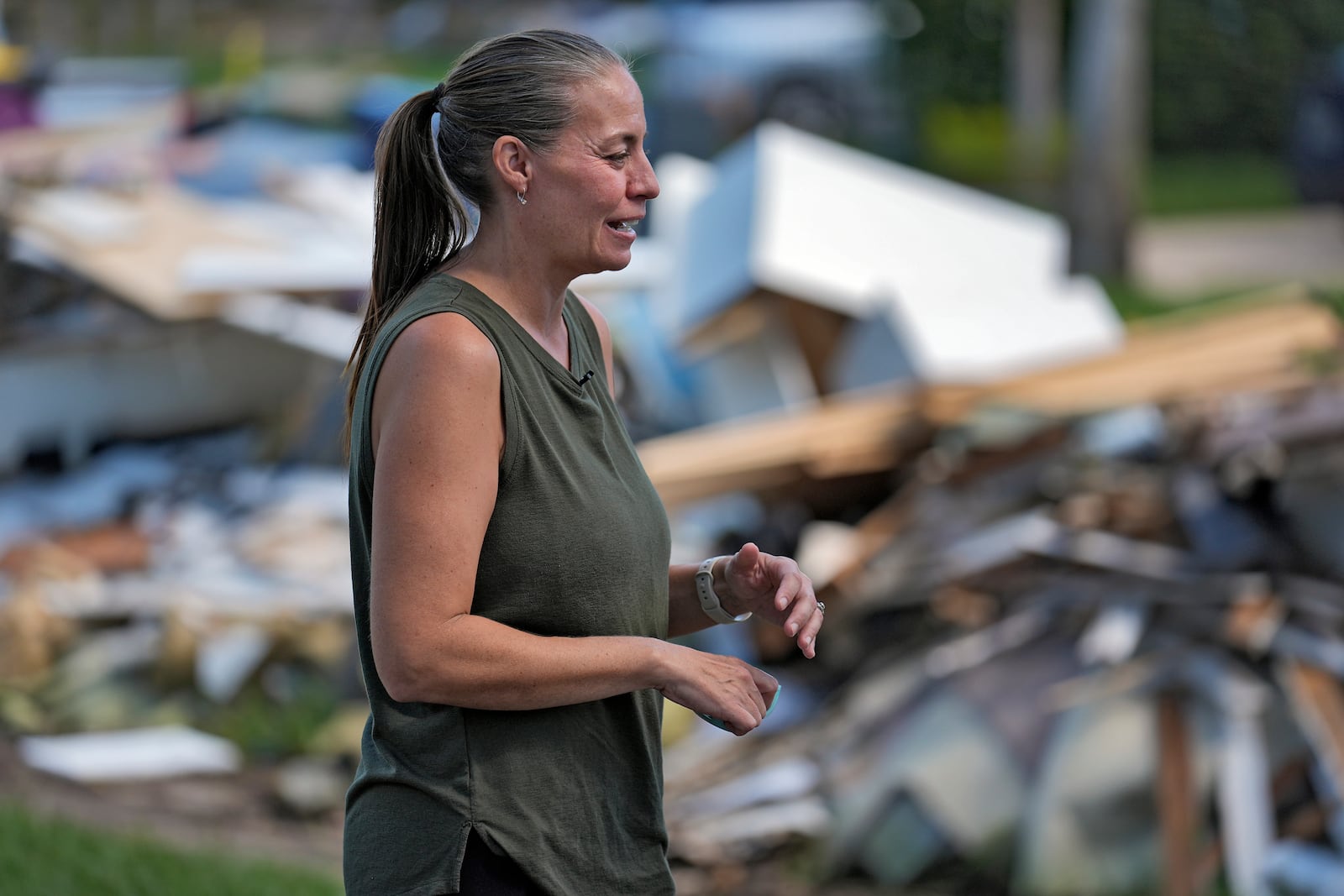 Brooke Carstensen sands near debris from Hurricanes Helene and Milton outside her home Sunday, Oct. 13, 2024, in Tampa, Fla. (AP Photo/Chris O'Meara)