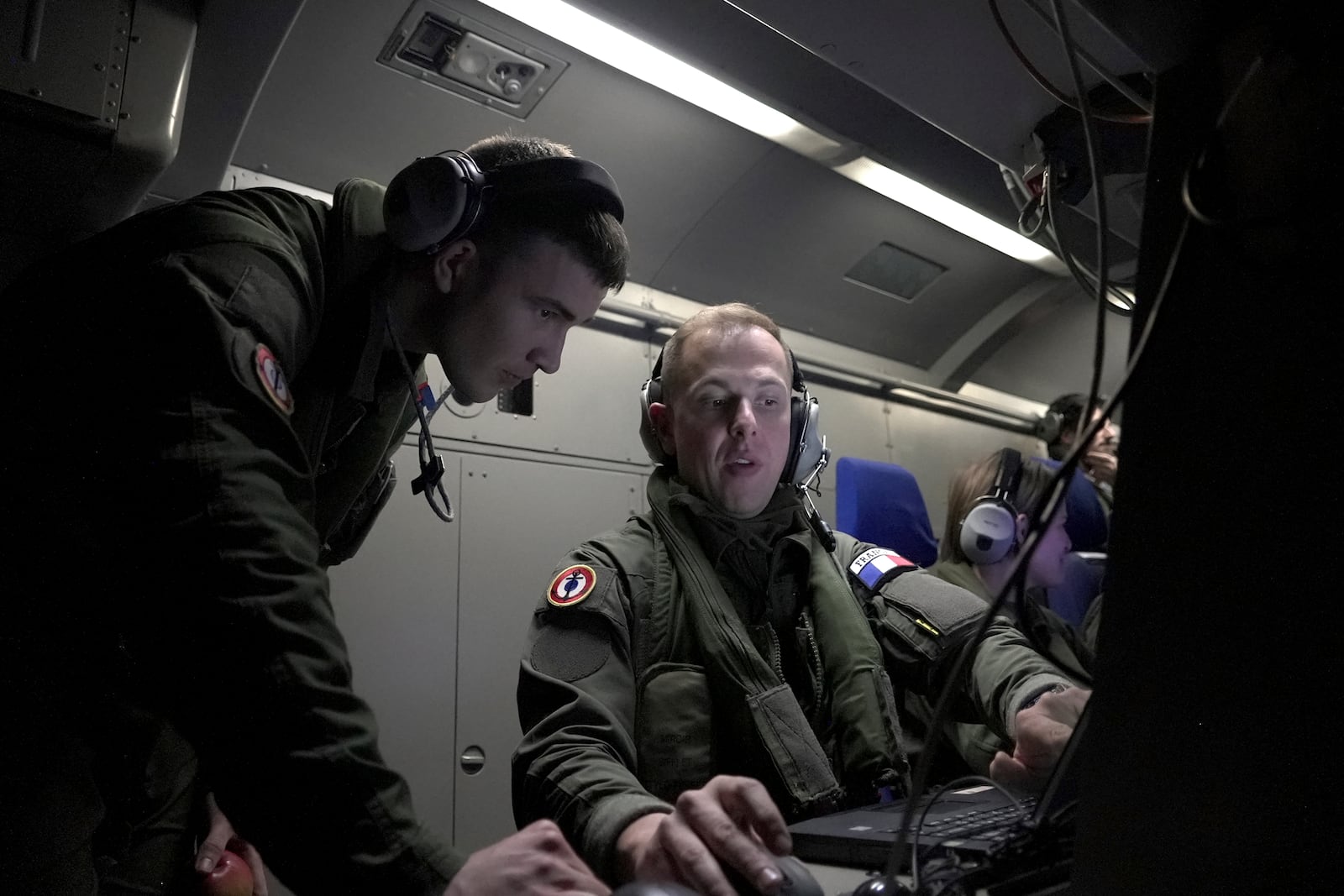 Crew members aboard a French Navy Atlantique 2 surveillance plane watch one of the classified onboard monitors showing data and images from the aircraft's radars, cameras and other sensors as it patrols Thursday, Jan. 23, 2025, over the Baltic Sea as part of the NATO military alliance's "Baltic Sentry" mission to protect undersea cables and pipelines from sabotage. (AP Photo/John Leicester)