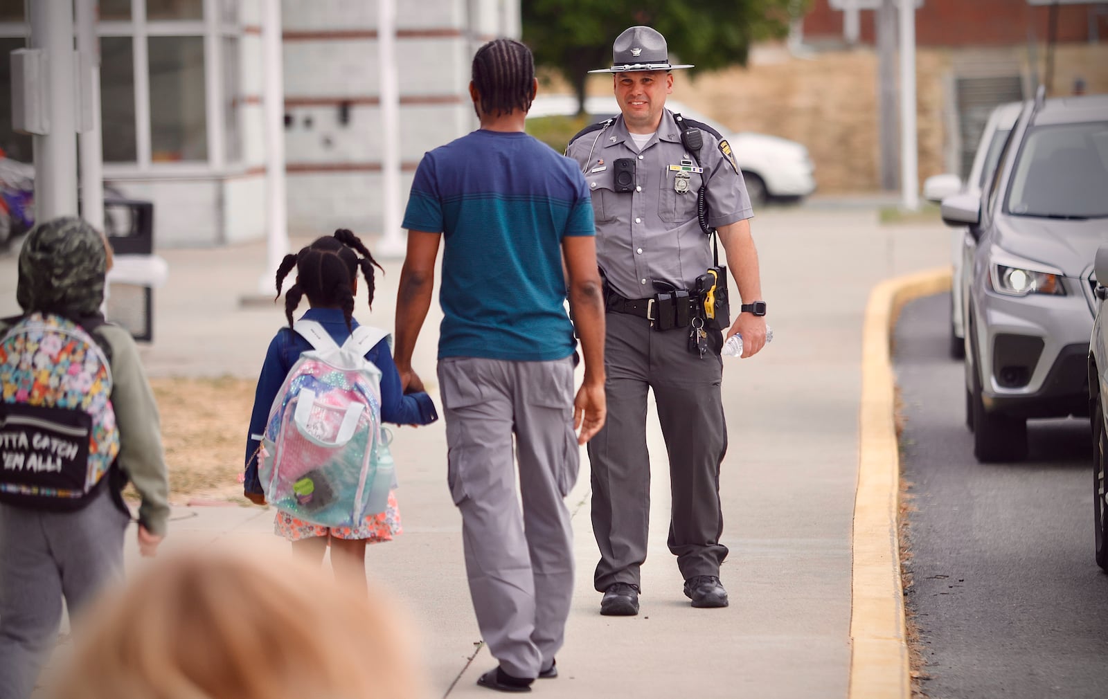 Sgt. Scott Schweinfuth of the Ohio State Highway Patrol greets parents and students Tuesday, September 17, 2024 at Snowhill Elementary in Springfield. MARSHALL GORBY\STAFF