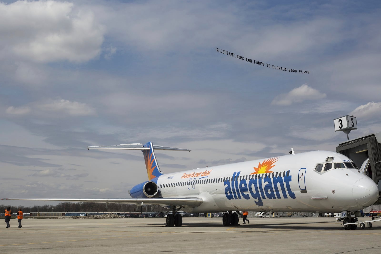 FILE - A small plane tows a banner over Flint Bishop Airport as part of ceremonies marking Allegiant Air joining Flint Bishop International Airport on April 13, 2016. (Conor Ralph/The Flint Journal- MLive.com via AP, File)