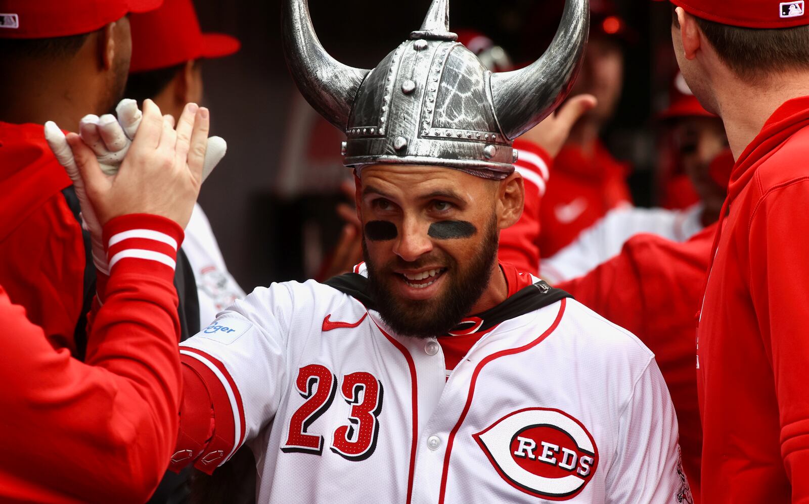 Nick Martini, of the Reds, celebrates with teammates in the dugout after hitting a two-run home run in the second inning on Opening Day on Thursday, March 28, 2024, at Great American Ball Park in Cincinnati. David Jablonski/Staff