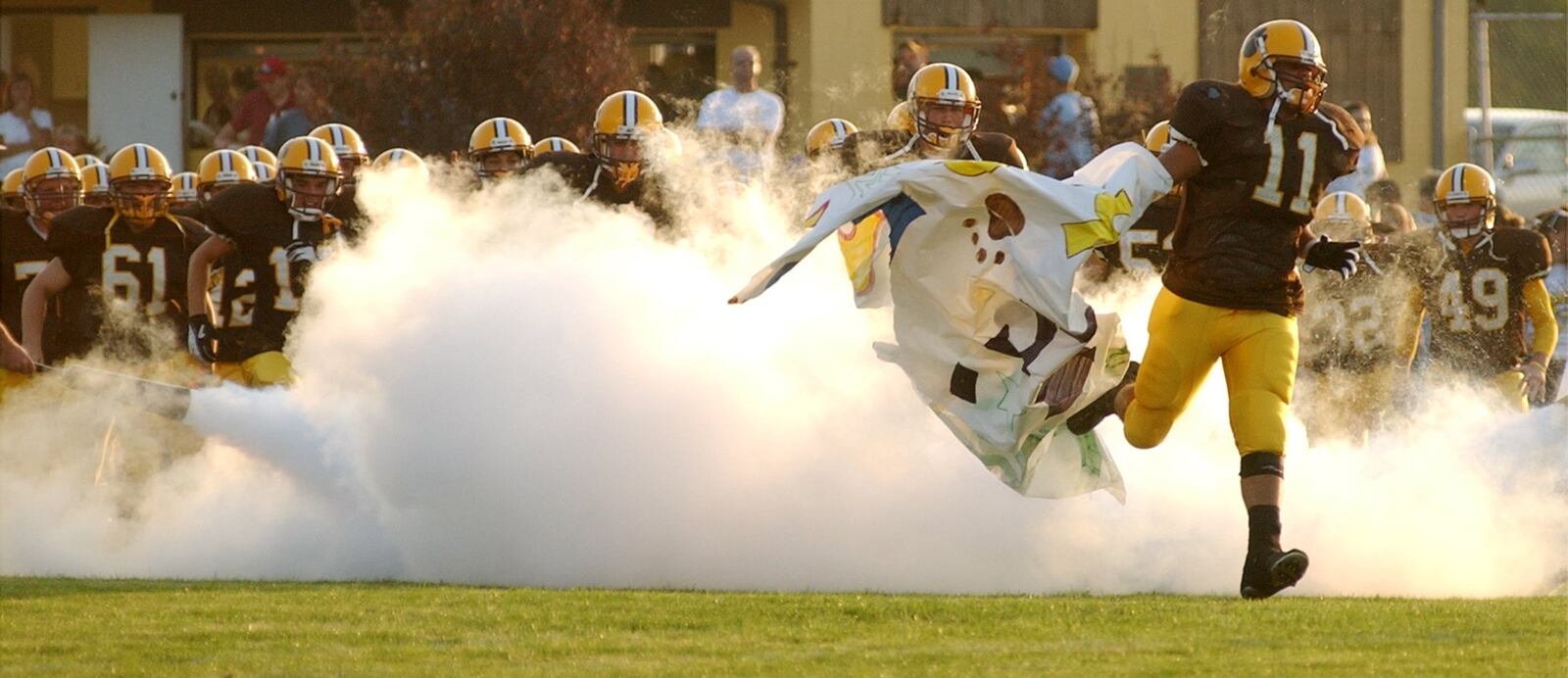 Kenton Ridge’s Brandon Downs leds the Kenton Ridge football team onto the field against Northeastern High School.