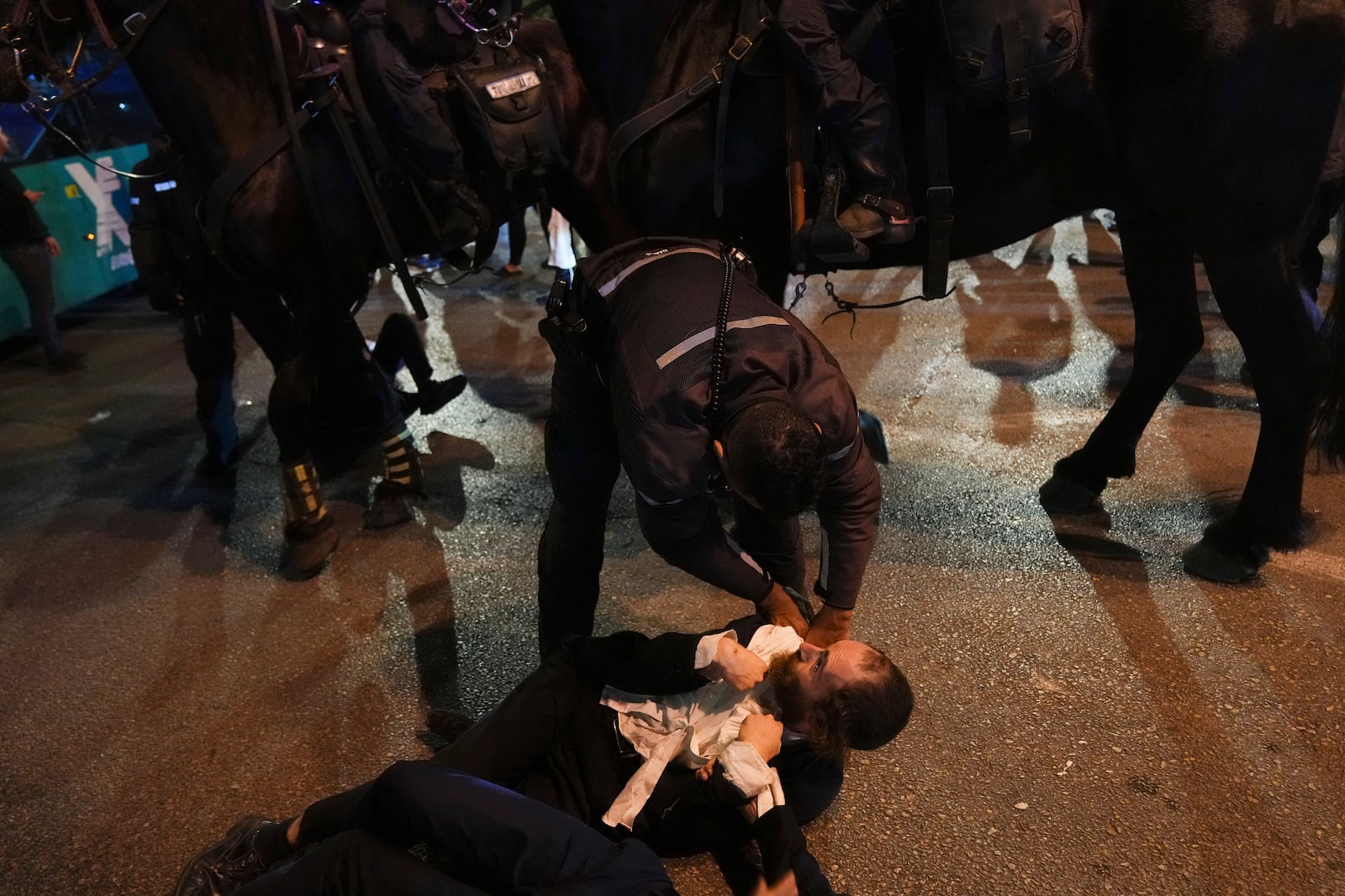 Israeli police officers disperse Ultra-Orthodox Jewish blocking a road during a protest against army recruitment in Bnei Brak, near Tel Aviv, Israel, Sunday, Nov. 17, 2024. (AP Photo/Francisco Seco)