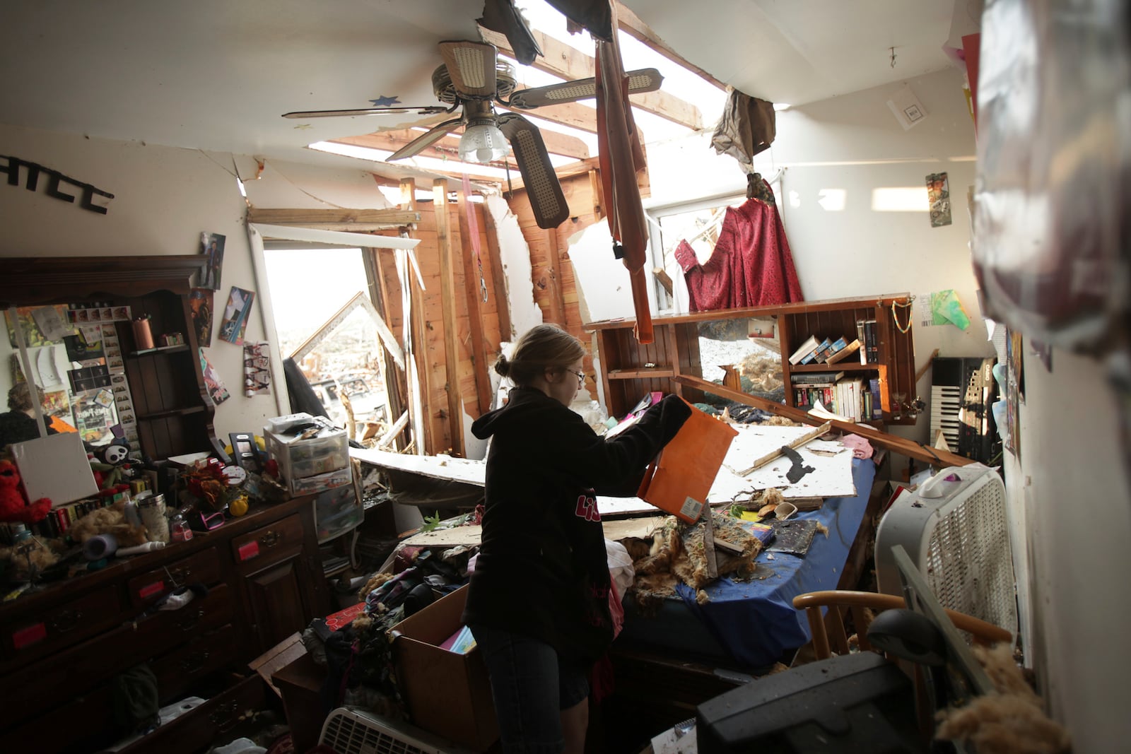 FILE - Candice Kell, 17, looks over her psychology textbook inside her grandmother's home in Joplin, Mo., Monday, May 23, 2011 after it was damaged by a tornado that destroyed nearly 30 percent of the town on Sunday afternoon. (Adam Wisneski/Tulsa World via AP,File)