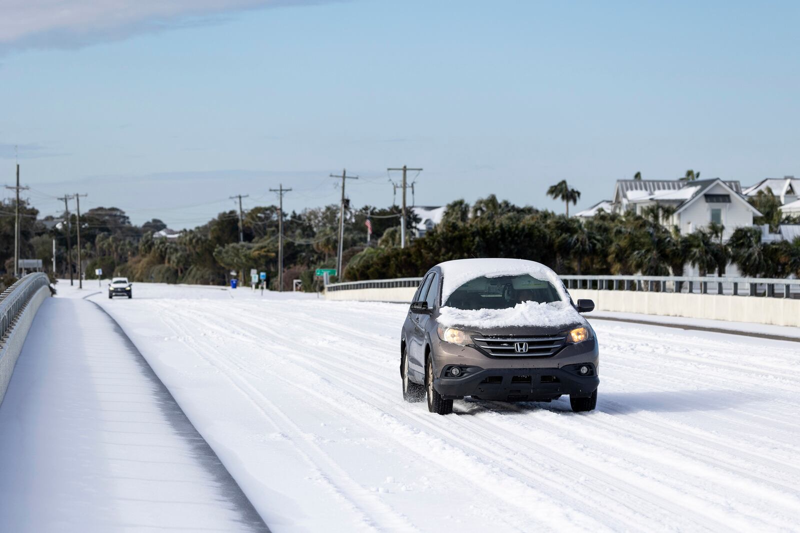 A car drives across the H.L. Hunley bridge after a winter storm dropped ice and snow Wednesday, Jan. 22, 2025, on the Isle of Palms, S.C. (AP Photo/Mic Smith)