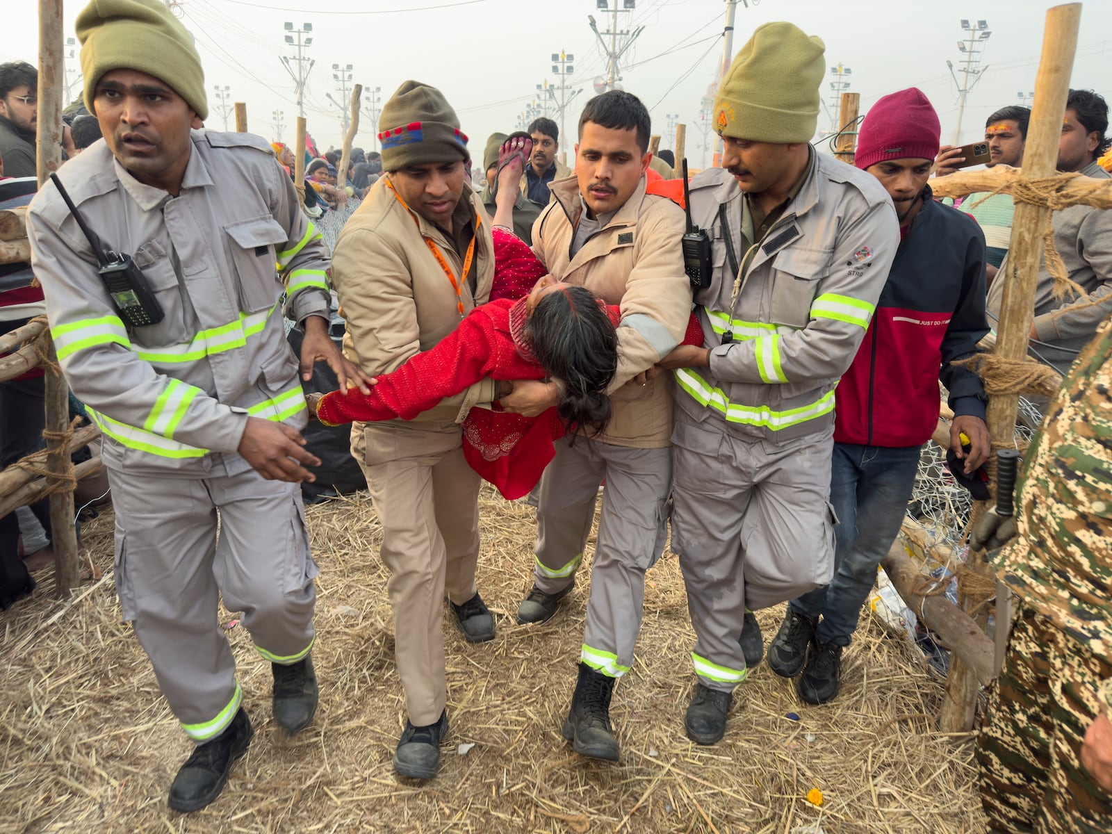 Security officers carry a woman out from the site of a stampede at the Sangam, the confluence of the Ganges, the Yamuna and the mythical Saraswati rivers, on "Mauni Amavasya" or new moon day during the Maha Kumbh festival, in Prayagraj, Uttar Pradesh, India, Wednesday, Jan. 29, 2025. (AP Photo/Rajesh Kumar Singh)