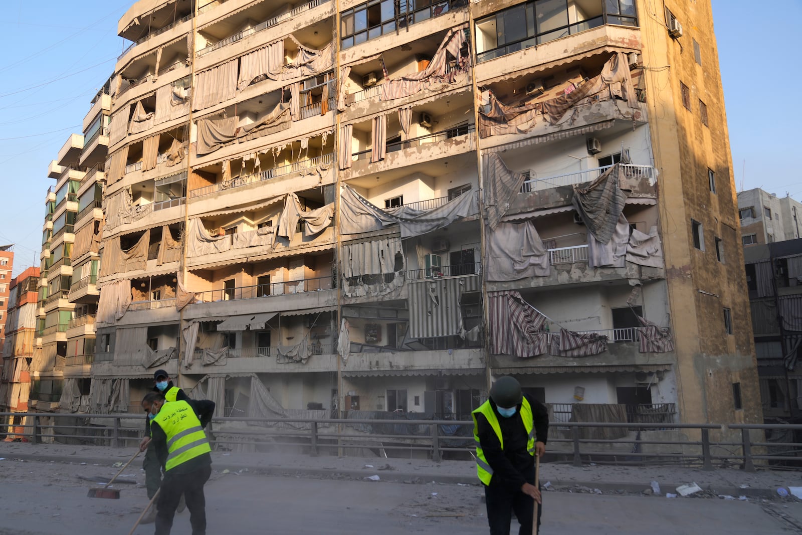 Workers remove the rubble in front of a damaged building that was hit by an Israeli airstrike on Dahiyeh, in the southern suburb of Beirut, Lebanon, Friday, Nov. 1, 2024. (AP Photo/Hussein Malla)