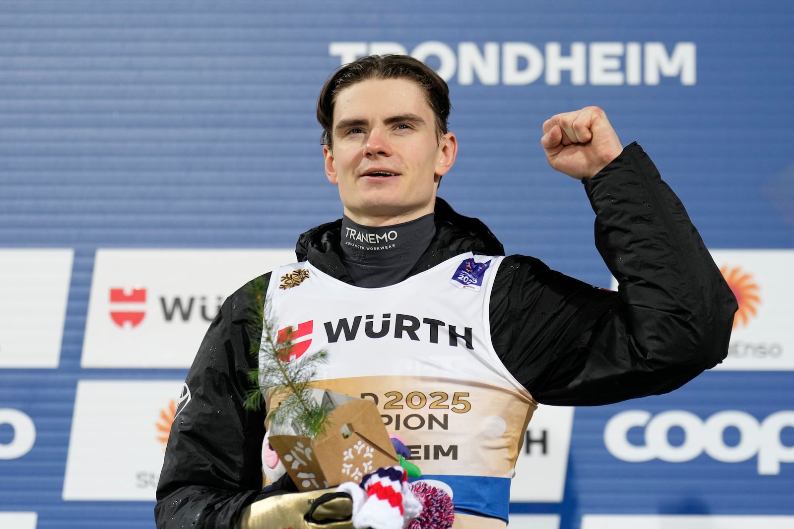 Marius Lindvik, of Norway, celebrates on the podium after winning the gold medal in the ski jumping men's normal hill HS102 event at the Nordic World Ski Championships in Trondheim, Norway, Sunday, March 2, 2025. (AP Photo/Matthias Schrader)