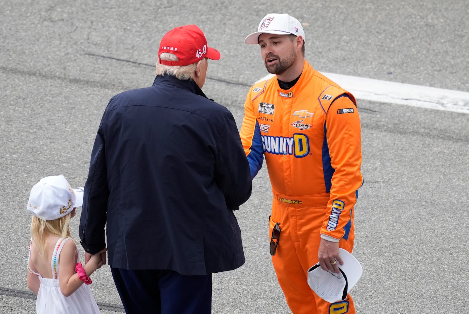 President Donald Trump, center, with his granddaughter Carolina, greets Ricky Stenhouse Jr. at the NASCAR Daytona 500 auto race at Daytona International Speedway, Sunday, Feb. 16, 2025, in Daytona Beach, Fla. (AP Photo/Chris O'Meara)