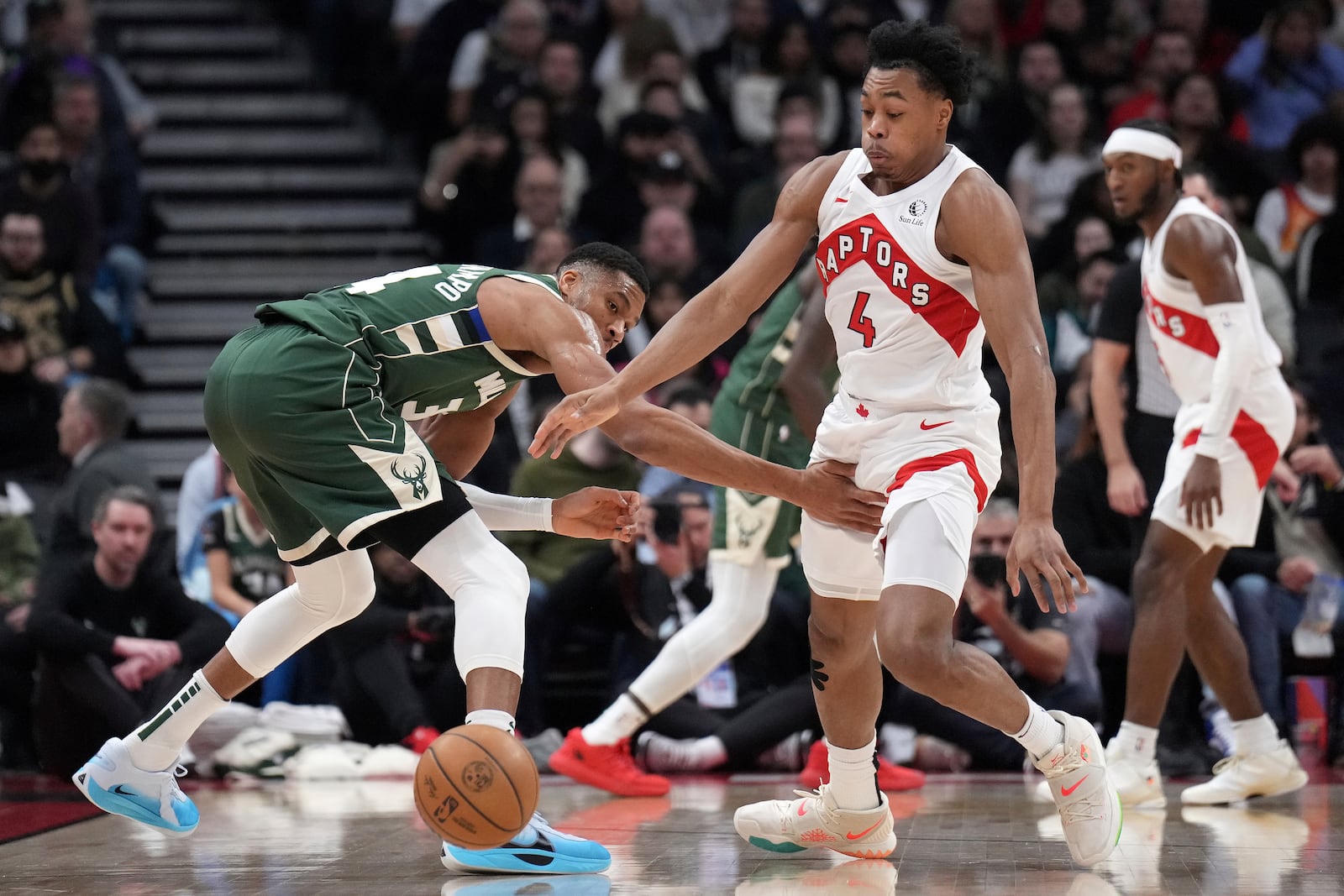 Toronto Raptors forward Scottie Barnes (4) steals the ball from Milwaukee Bucks forward Giannis Antetokounmpo during the first half of an NBA basketball game in Toronto, Monday, Jan. 6, 2025. (Nathan Denette/The Canadian Press via AP)