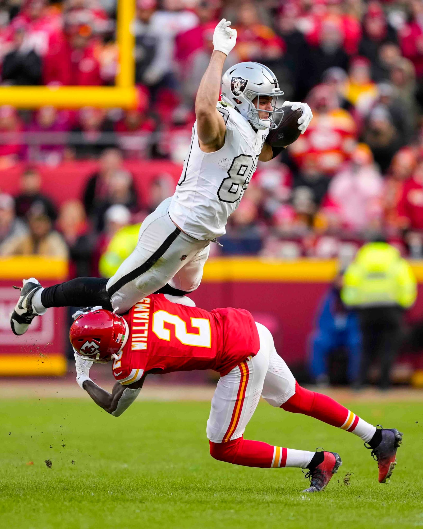 Las Vegas Raiders tight end Brock Bowers (89) tries to leap over Kansas City Chiefs cornerback Joshua Williams (2) during the first half of an NFL football game in Kansas City, Mo., Friday, Nov. 29, 2024. (AP Photo/Ed Zurga)