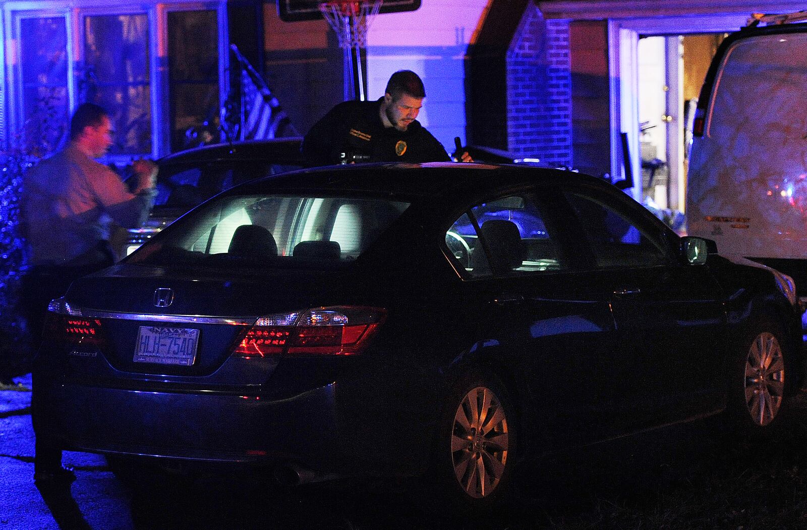 Members of the Springfield Police Division look over a car at a home on Selma Pike Sunday night Nov. 6, 2022 involved in homicide on Willis Ave. in Springfield. MARSHALL GORBY\STAFF