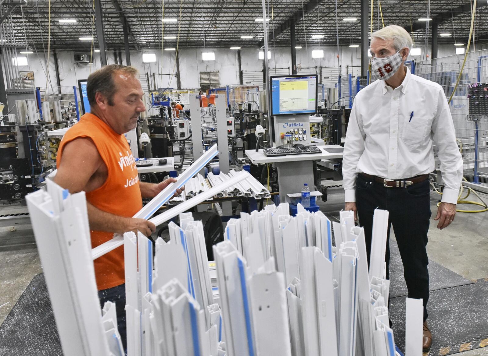 U.S. Sen. Rob Portman, R-Cincinnati, talks with 20-plus year Vinylmax Windows employee James Miller as he tours the Hamilton plant Monday, August 31, 2020. Vinylmax is one of the local businesses who received a payroll protection program loan to keep its employees on payroll during the COVID-19 pandemic. NICK GRAHAM/STAFF