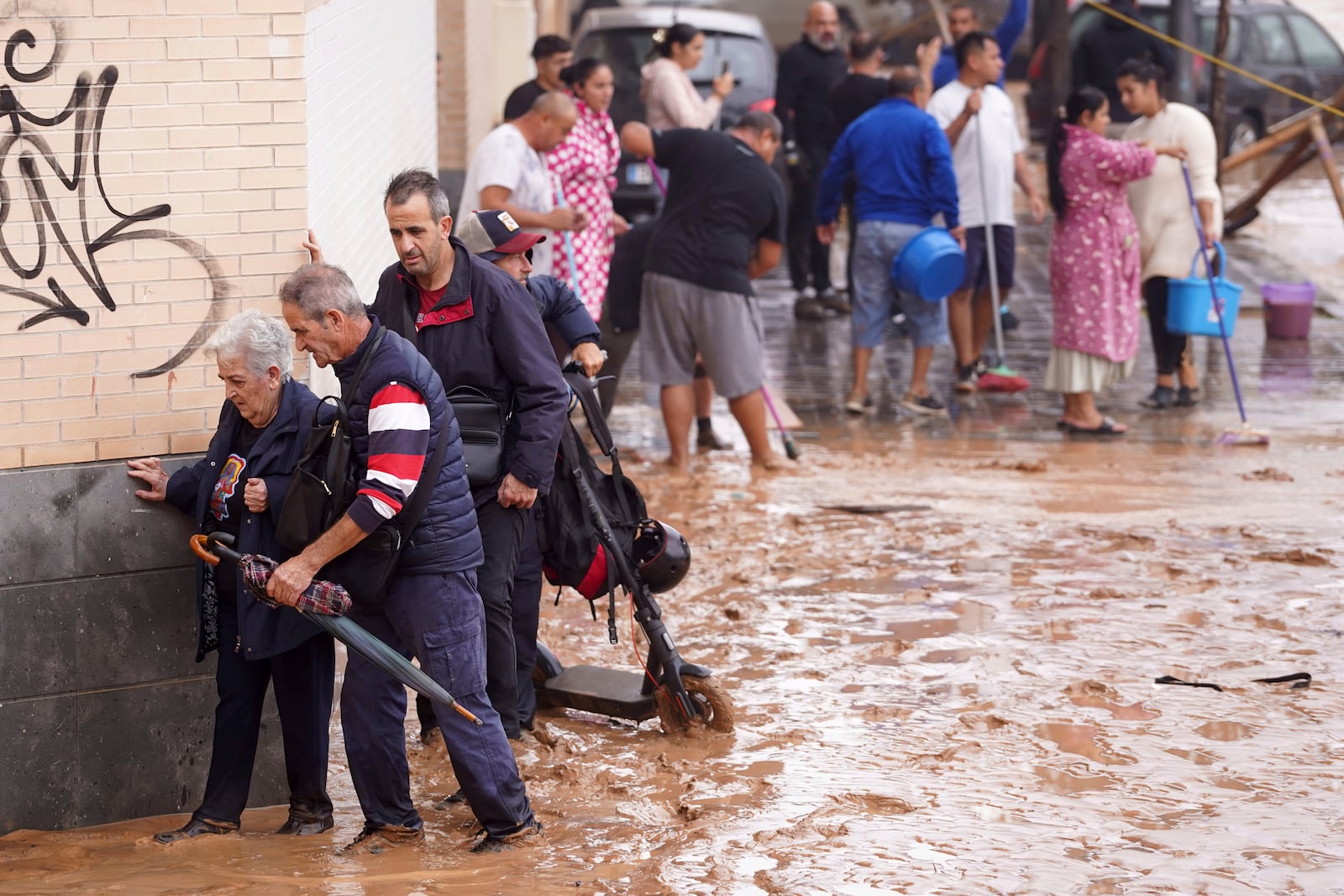 People walk through flooded streets in Valencia, Spain, Wednesday, Oct. 30, 2024. (AP Photo/Alberto Saiz)